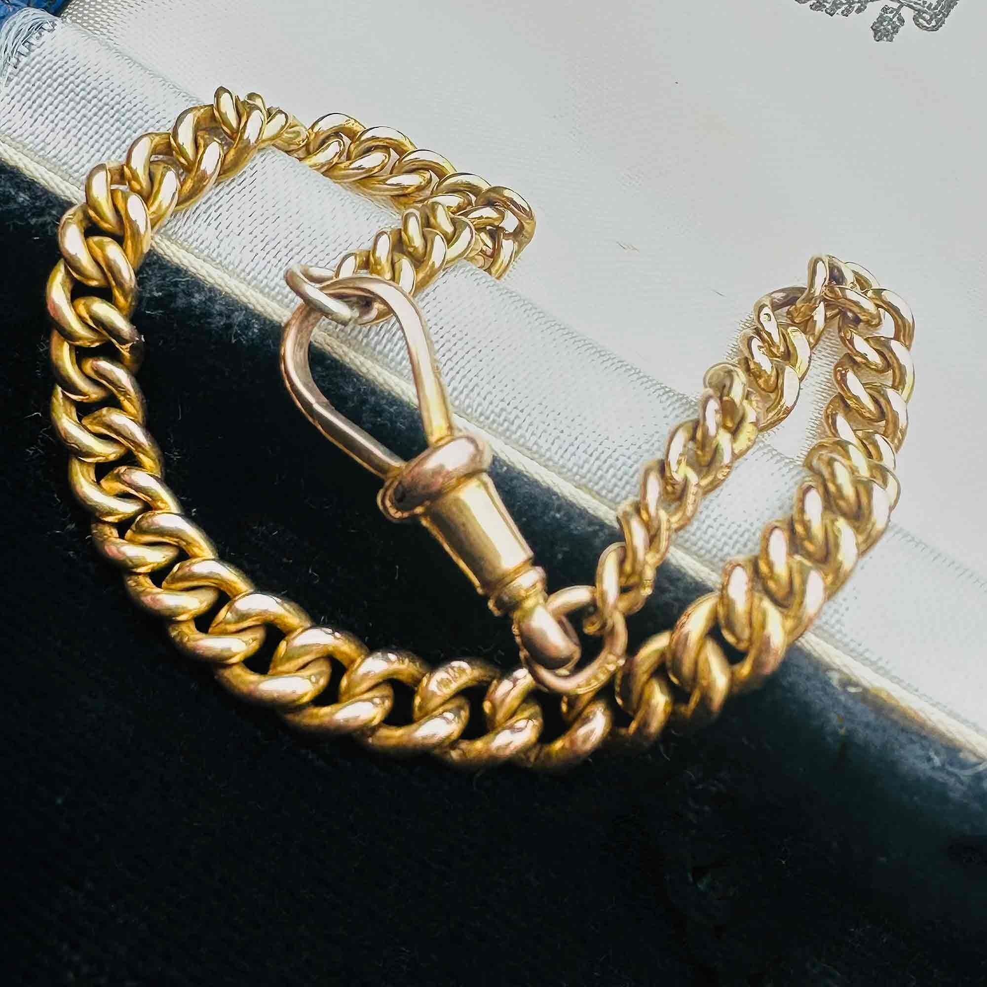 Gold Albert Curb Link  Bracelet & Dog Clip Clasp displayed laying on antique box