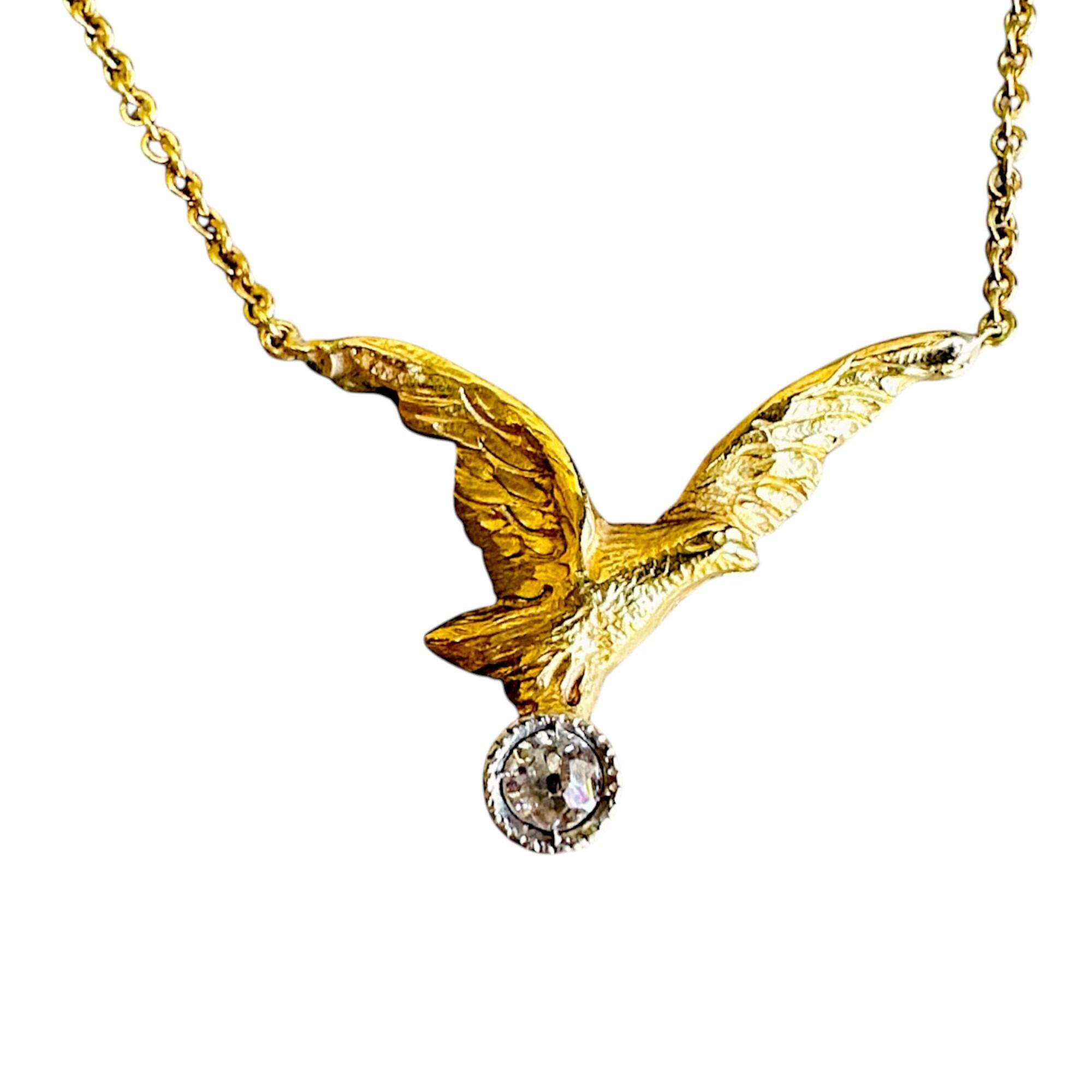 Front view of 18K gold eagle pendant necklace with a sparkling diamond in the eagle’s claws.