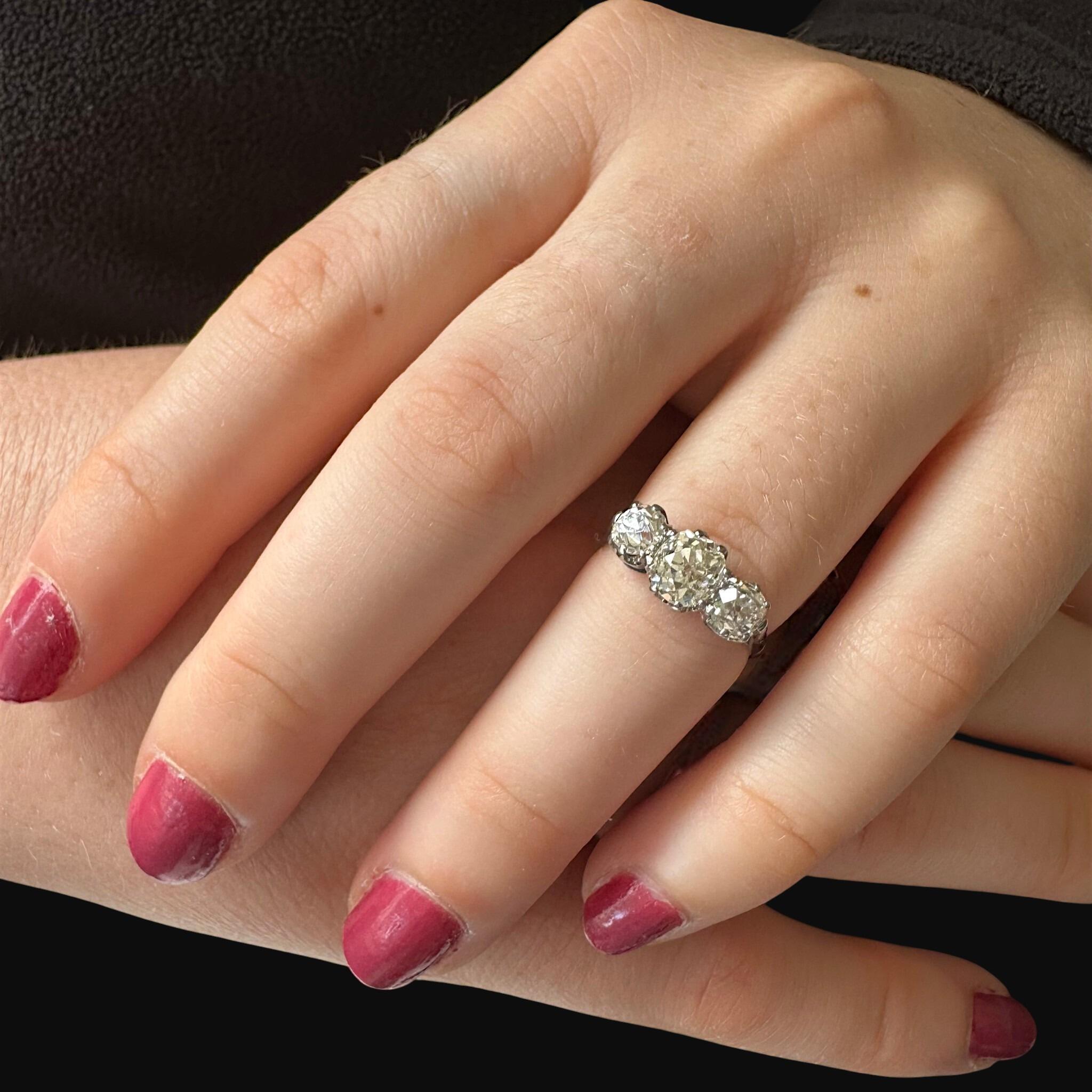 Antique Platinum Old Cushion Cut Diamond Trilogy Ring worn on models hand