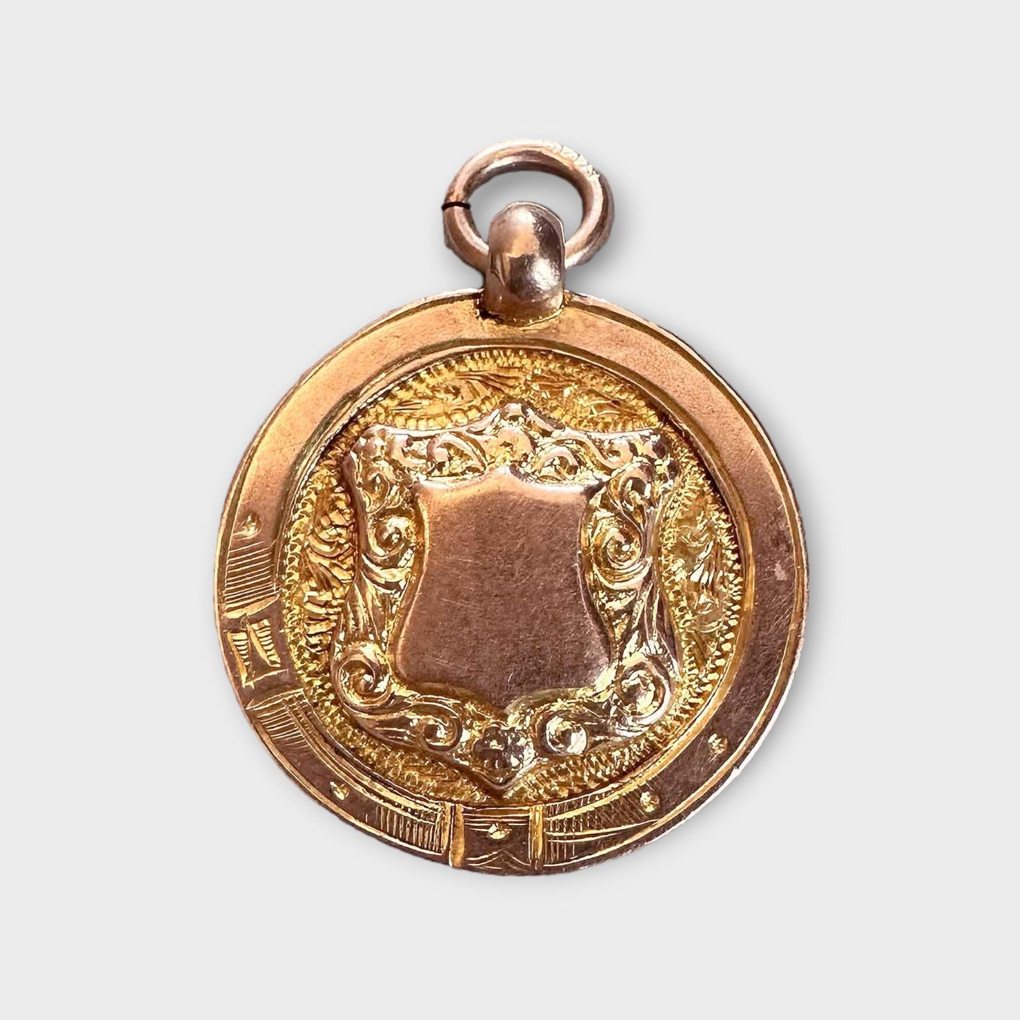 Antique 9ct rose gold medallion with Chester 1924 hallmark by maker P&M on grey background.