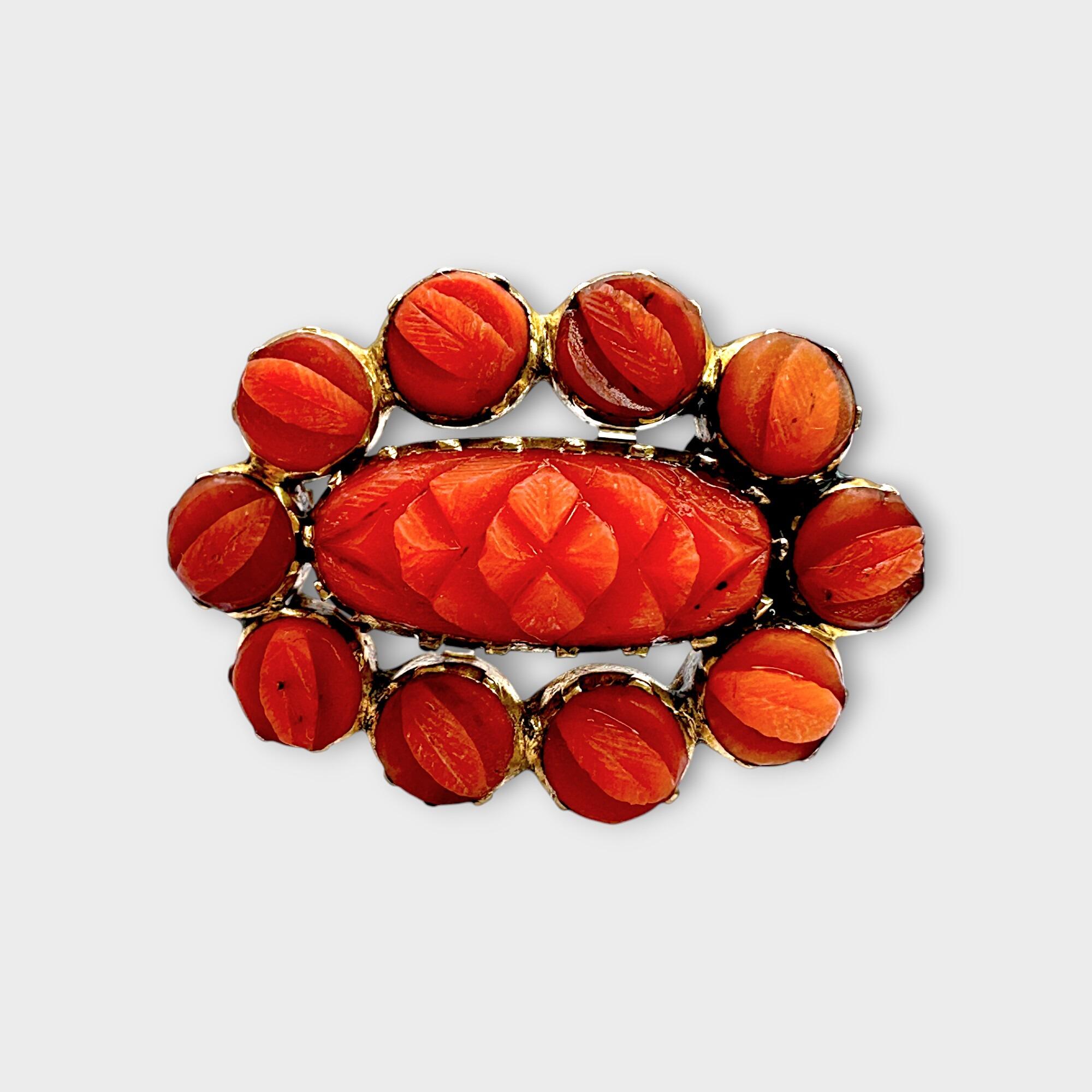 Georgian hand carved natural coral fichu brooch on grey background.