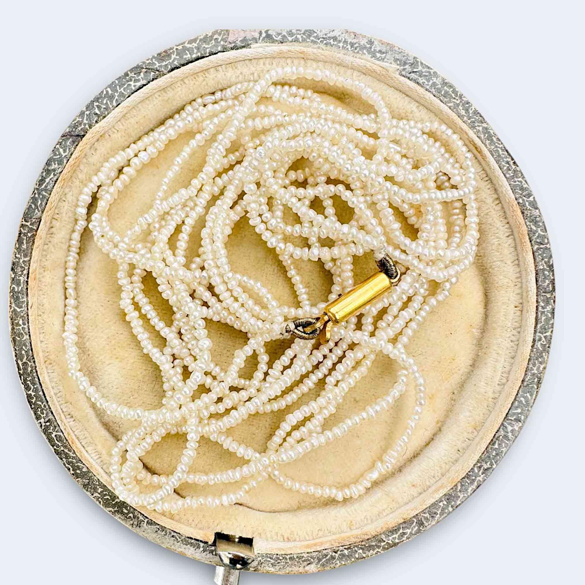 Georgian seed pearl four row necklace on 9k gold barrel clasp on antique box.