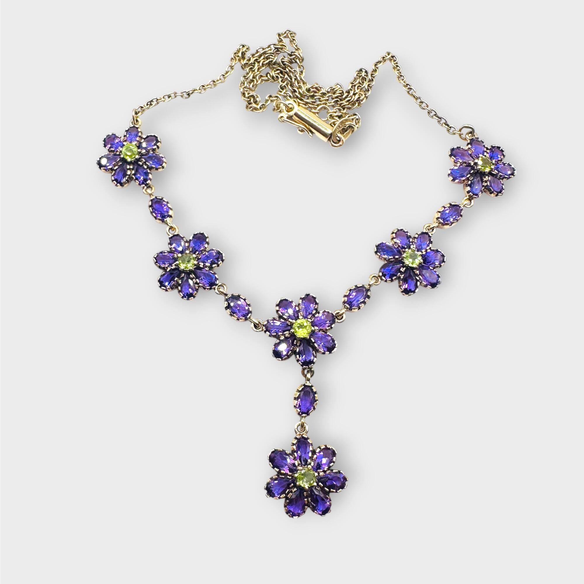 Art Nouveau 9k gold Amethyst and Peridot suffragette lavaliere necklace on grey background.