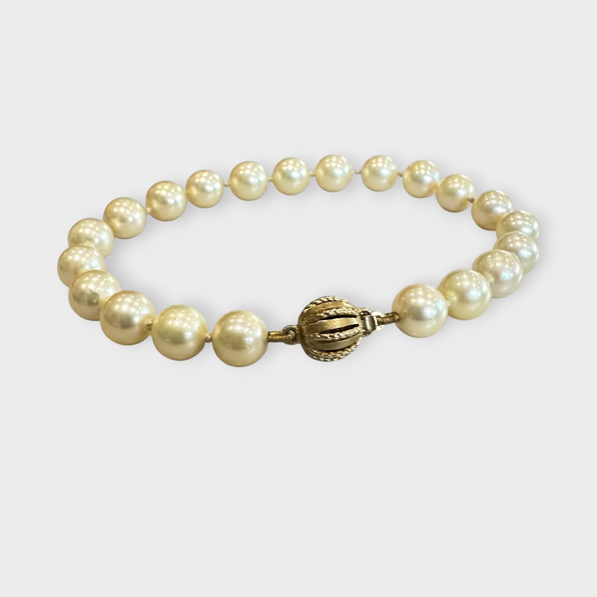 Cultured Saltwater Pearl Bracelet with 9ct Gold Ball Clasp, grey background.