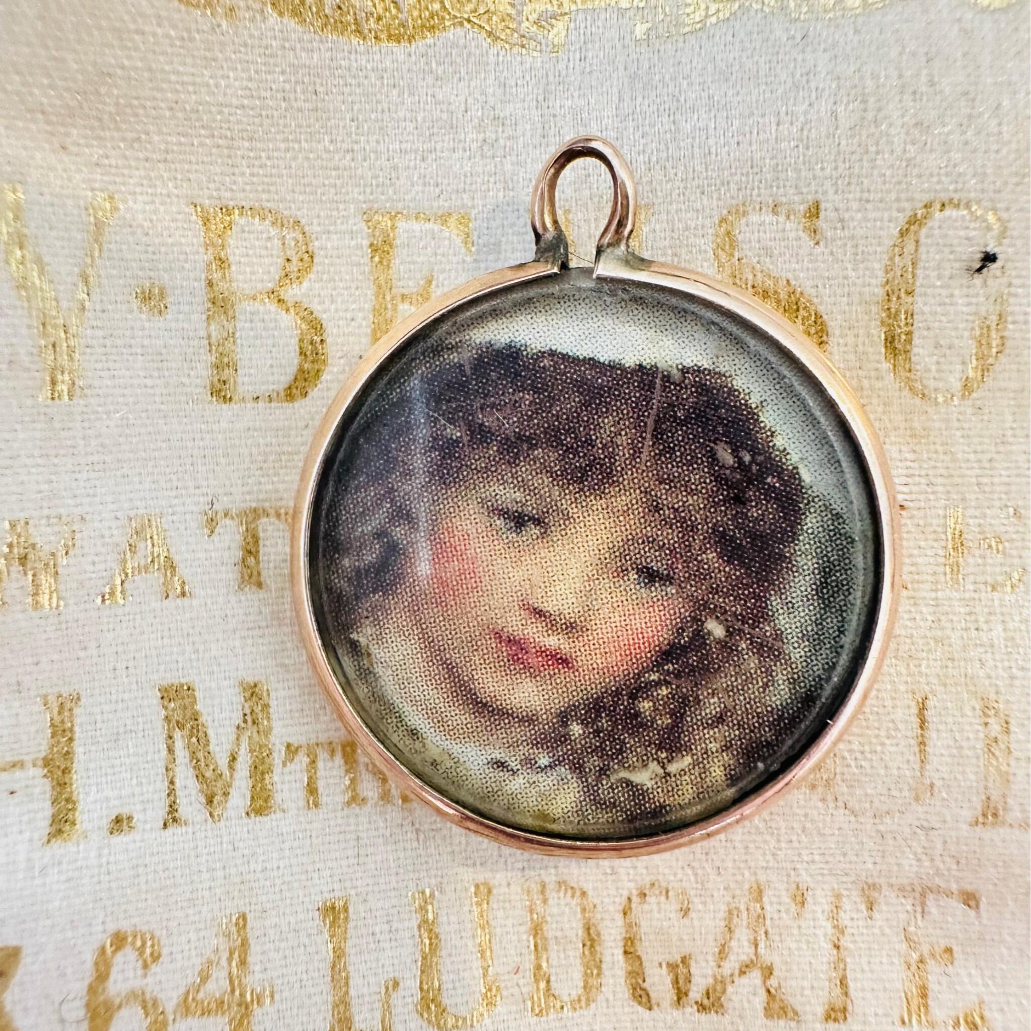 Art Nouveau Rose Gold Locket with Portrait laying on an antique box