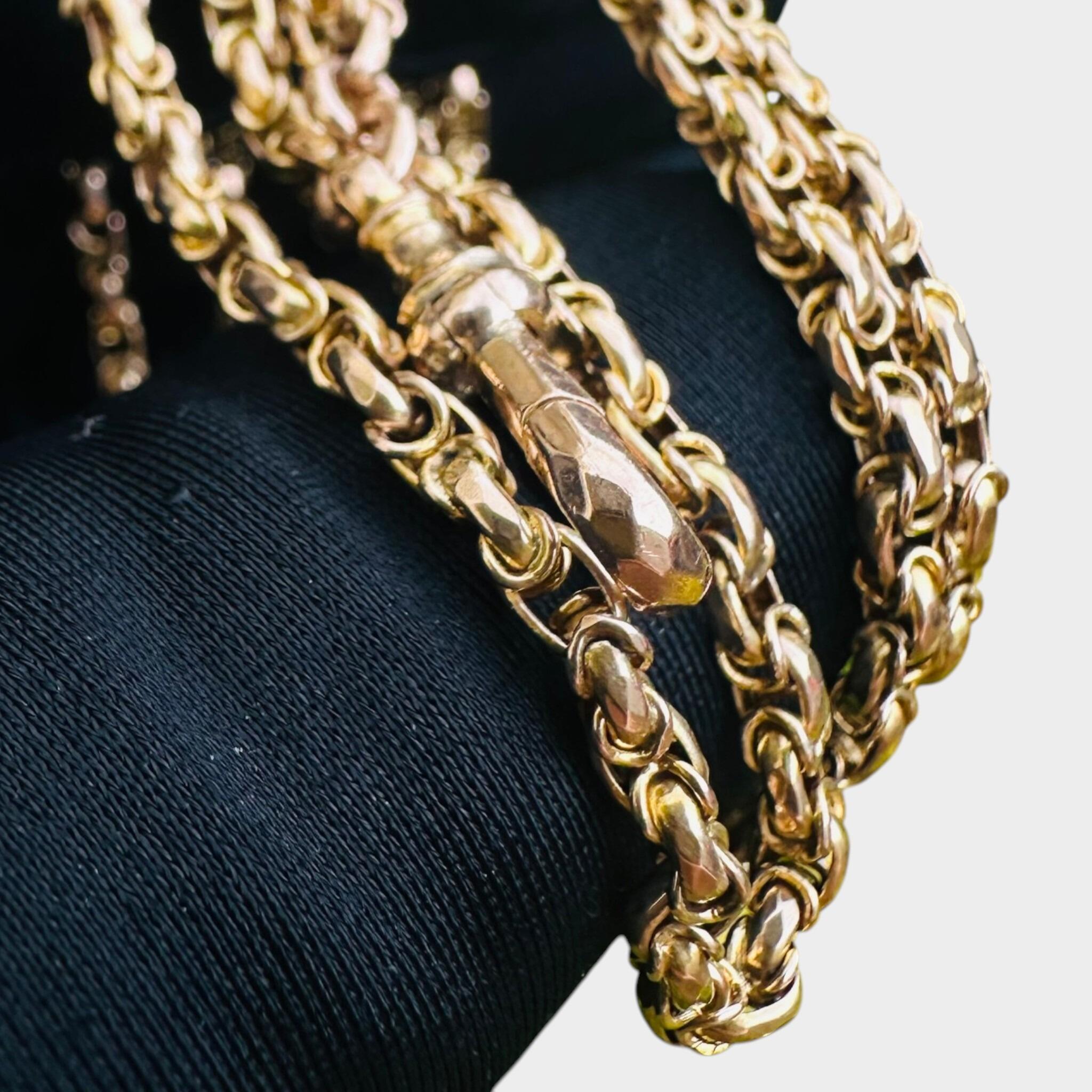 Victorian Gold Fancy Link Long Chain Necklace & Dog Clip held in black glove with grey background