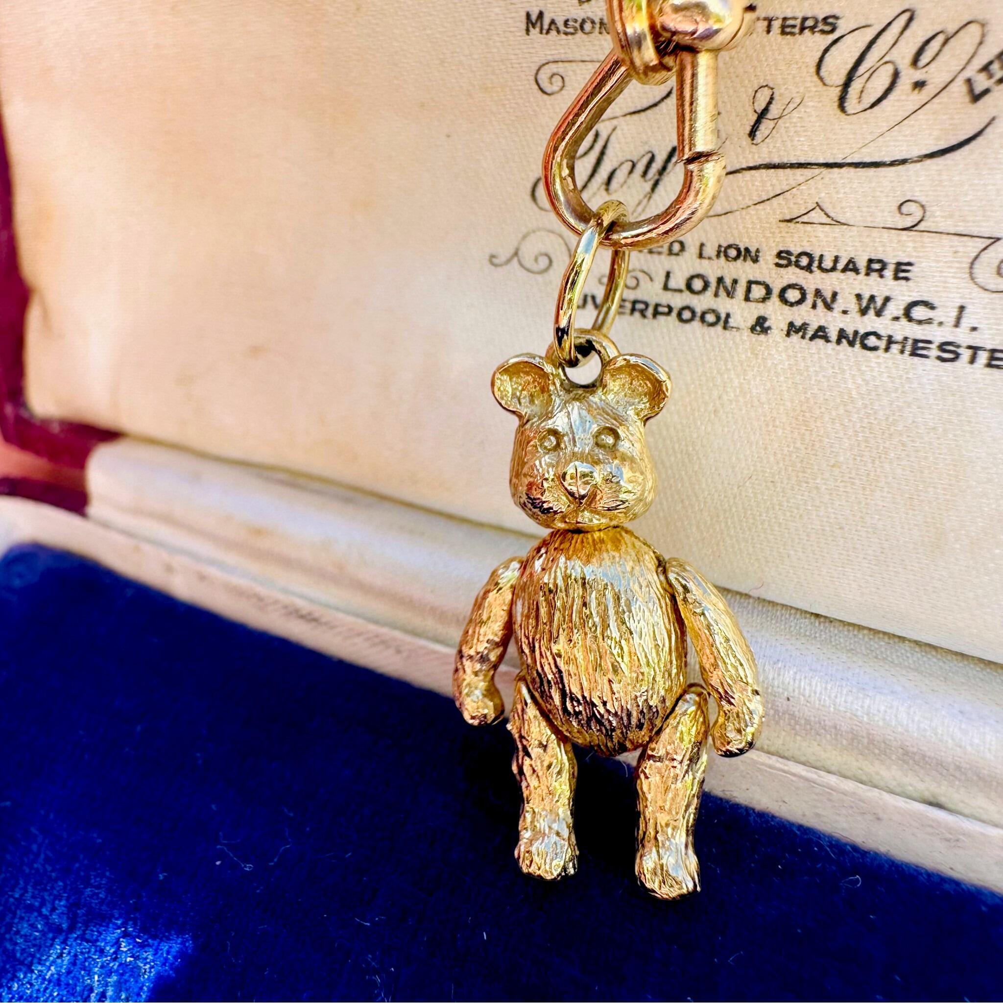 Vintage Gold Articulated Teddy Bear Charm Pendant, displayed on gold chain with antique box background