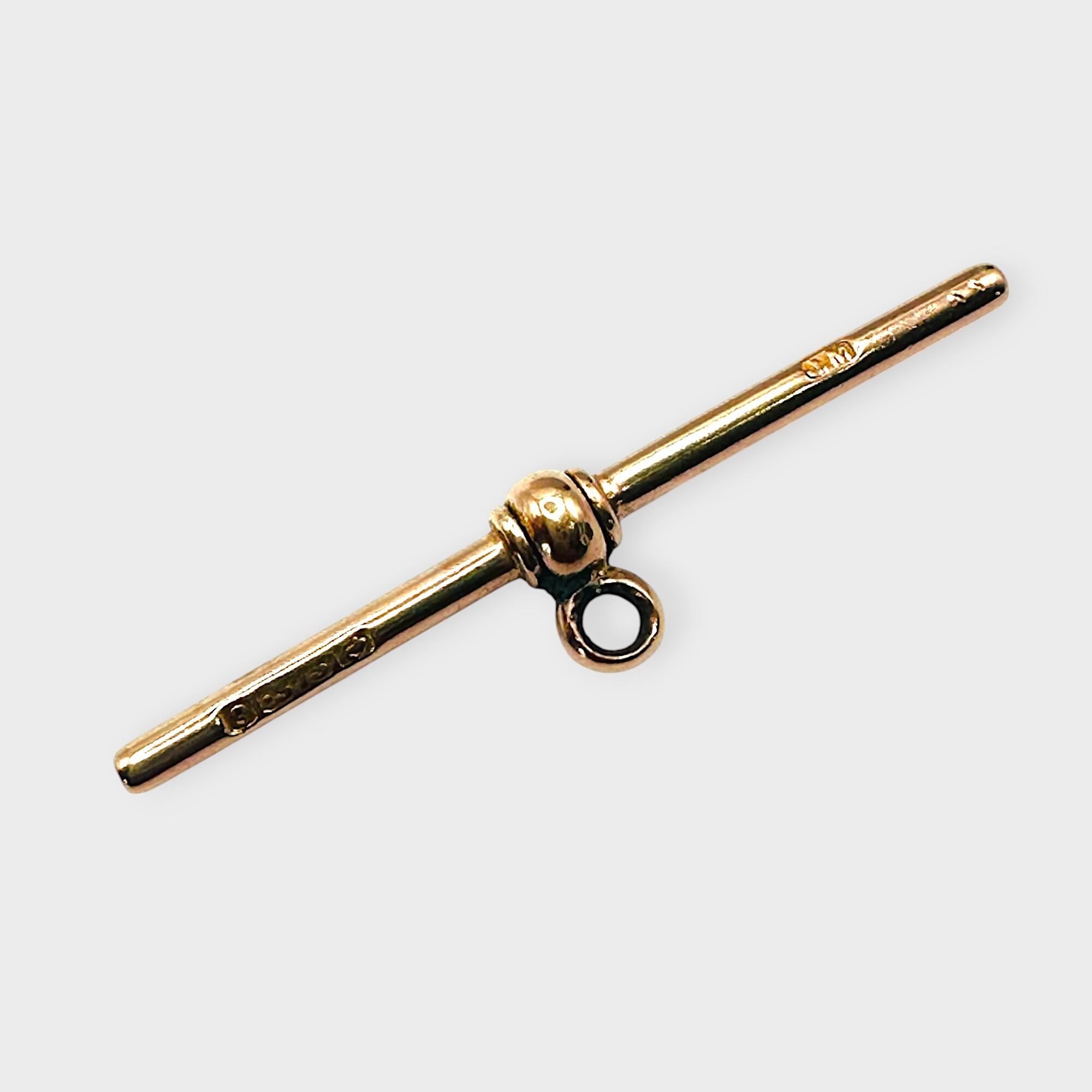 Antique, 9ct rose gold T-bar fitting on grey background.
