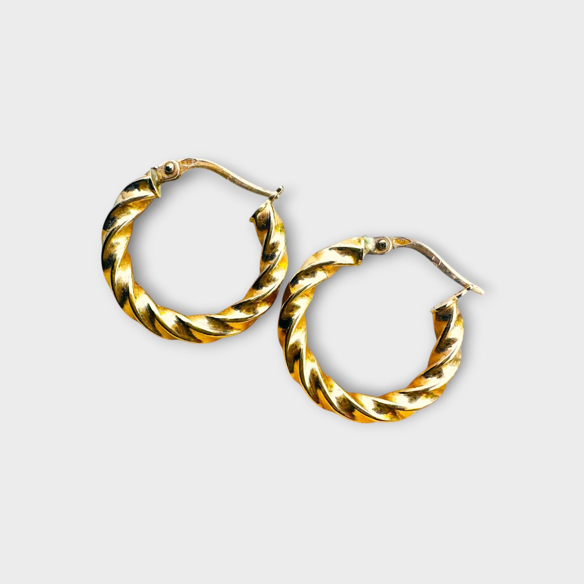 Italian 9k yellow gold twist rope hoop earrings on grey background.