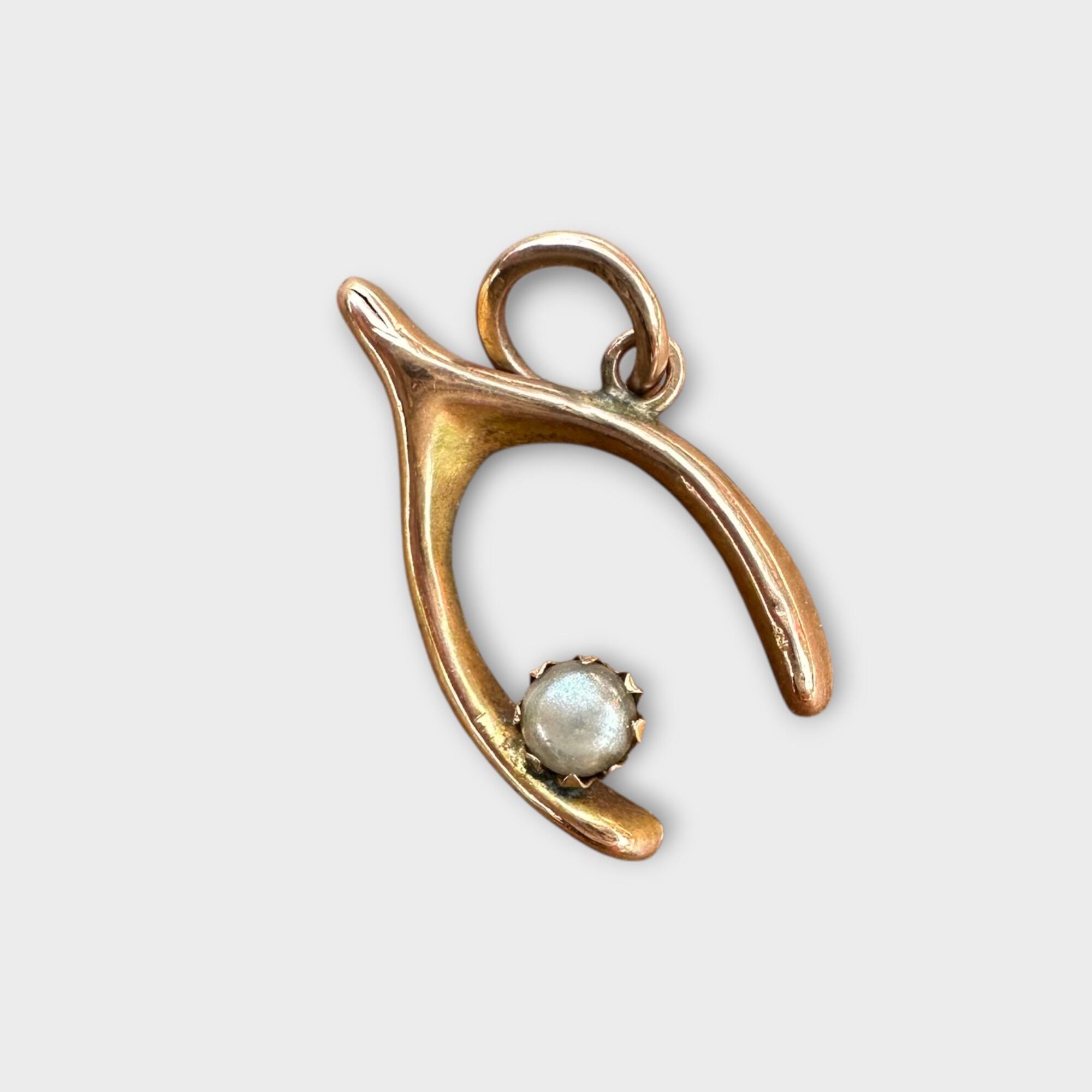 Pretty Victorian wishbone and pearl charm charm made of 9ct (375) rosegold, featuring a delicate wishbone design adorned with a single white pearl on grey background.