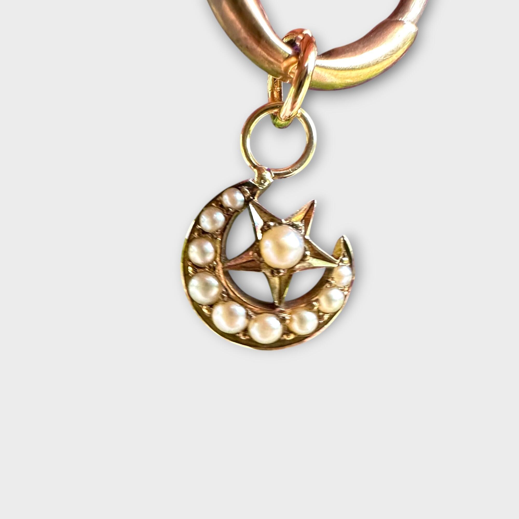Edwardian 15k gold crescent moon and star pendant with seed pearls, grey back ground.