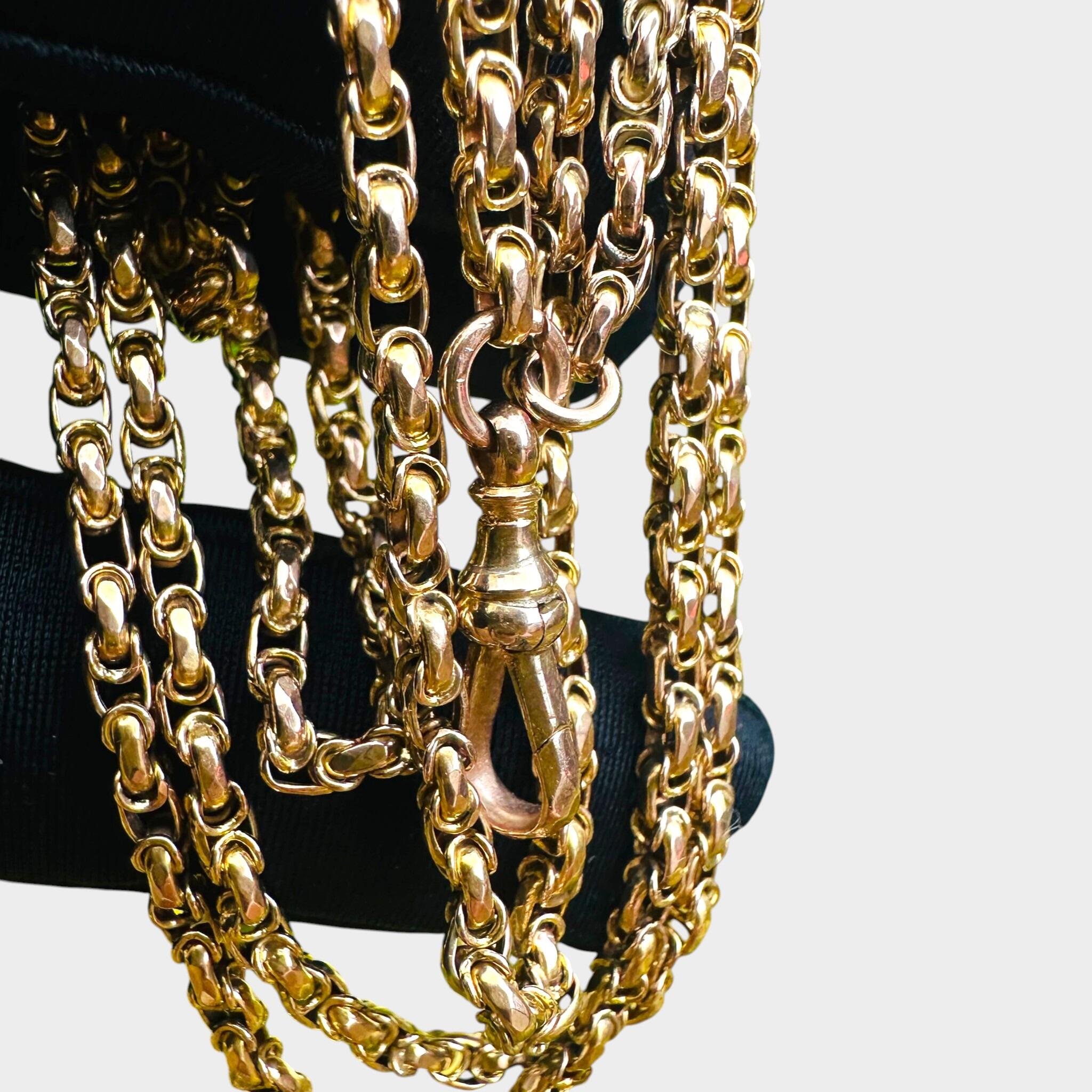 Victorian Gold Fancy Link Long Chain Necklace & Dog Clip held in black glove with grey background