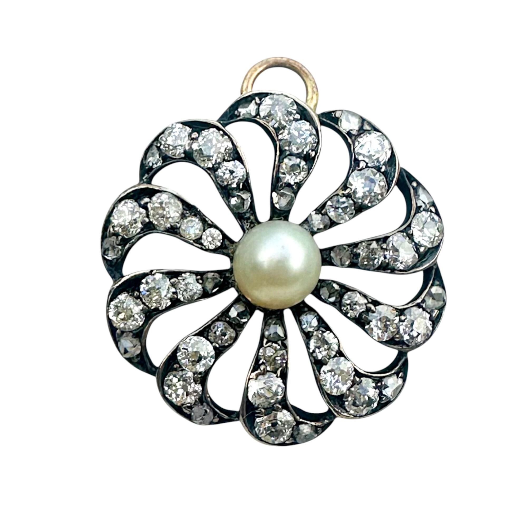 antique diamond and pearl celestial sunburst pendant with a white background.