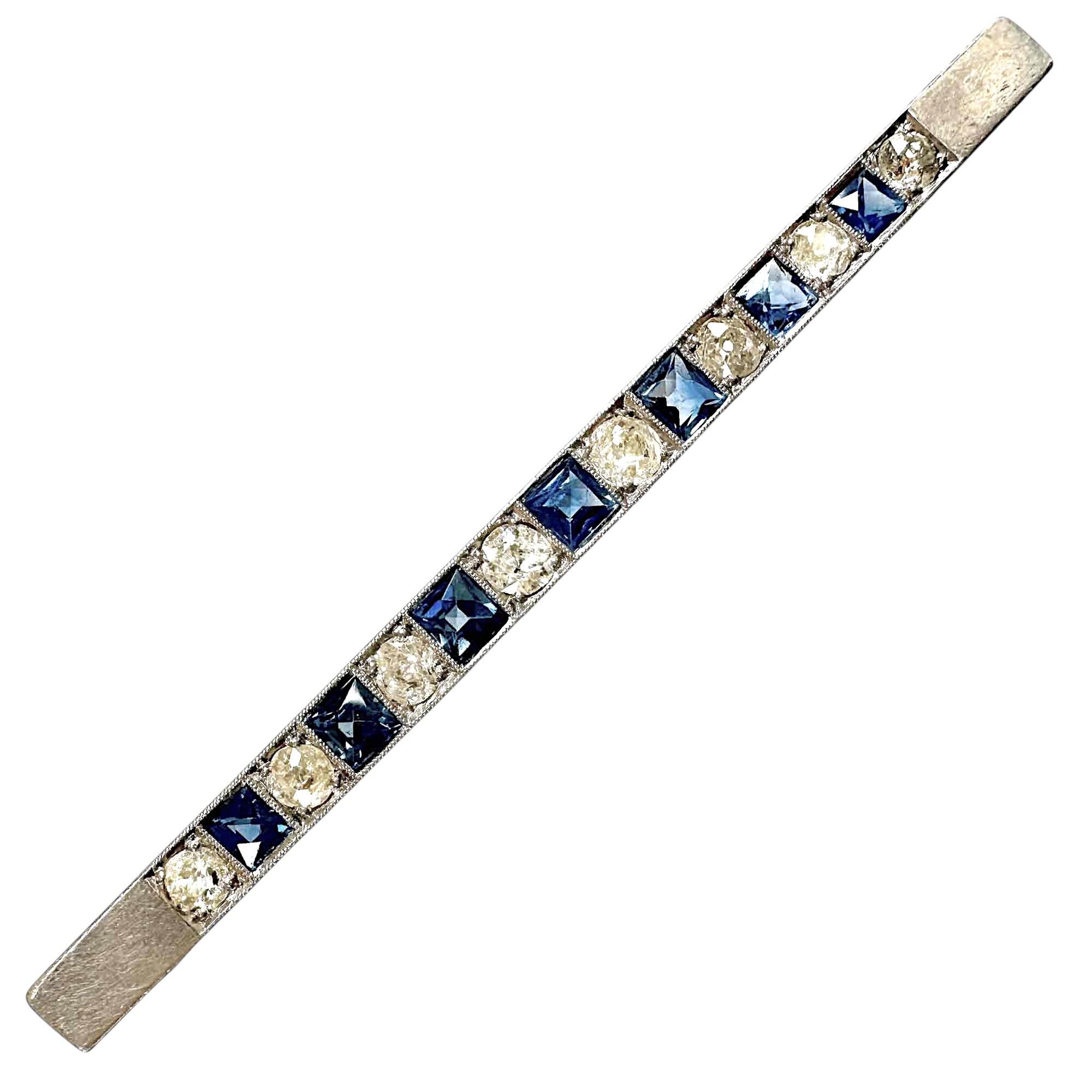 Art deco platinum line brooch with alternating diamonds and sapphires in millgrain settings