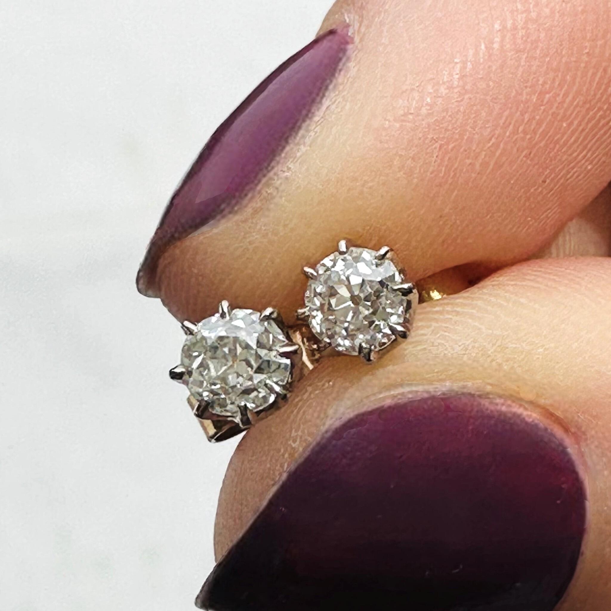 Antique 18k Gold Old European Cut Diamond Stud Earrings held between fingers with white background