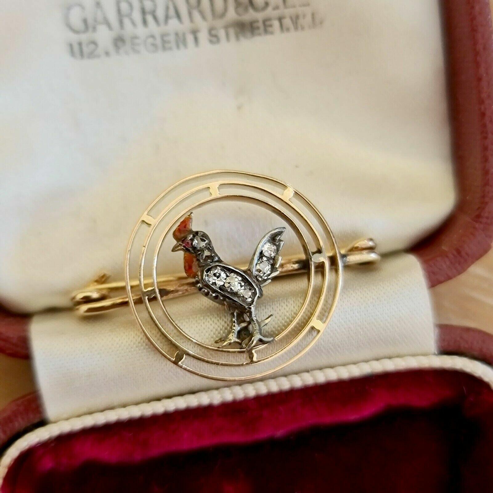 Antique bird circlet brooch with diamonds, ruby eye, and gold accents. Edwardian era, 18.5 x 28mm.