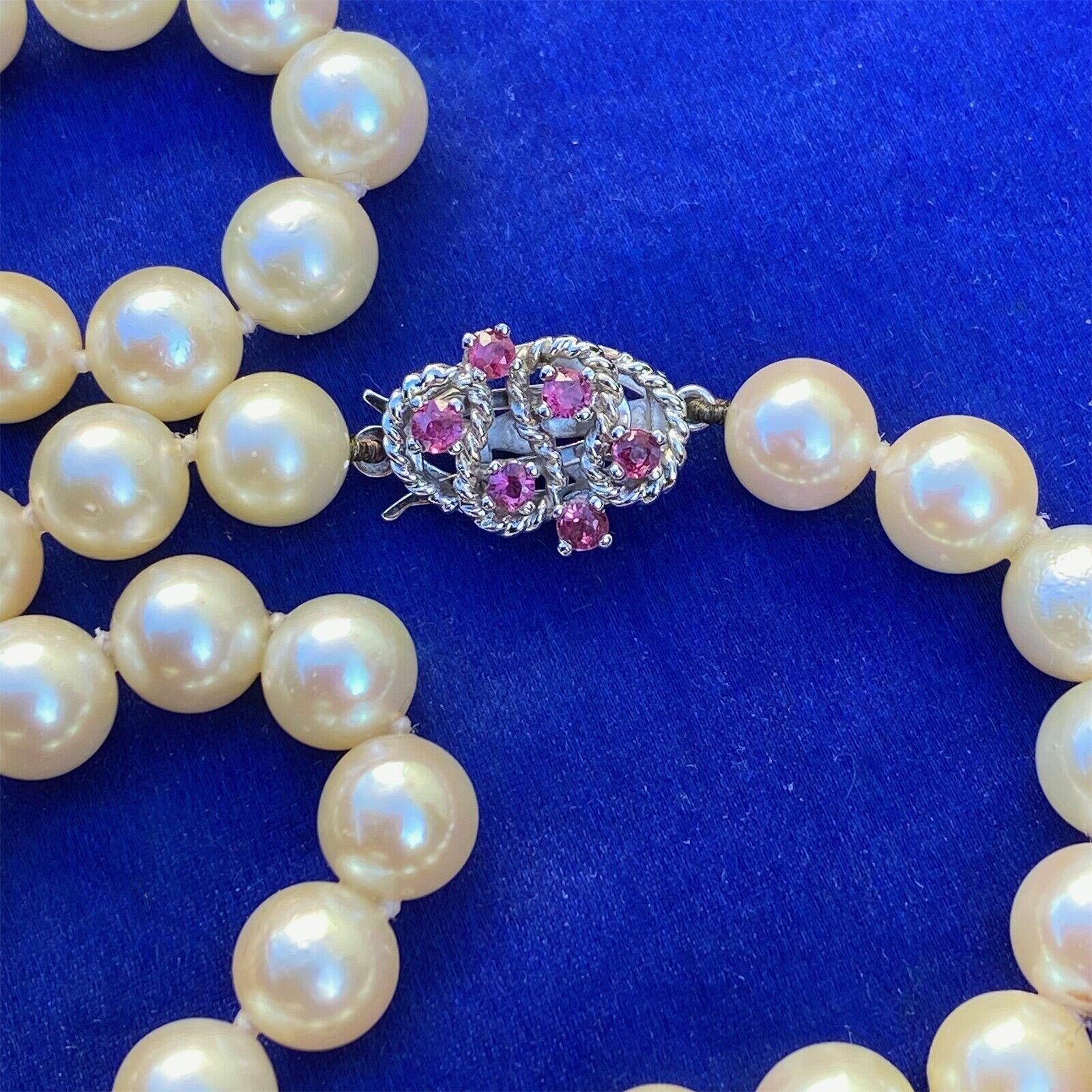 Elegant cultured pearl necklace with 14ct white gold ruby clasp, featuring 46 pearls in cream with pink hues and 6 faceted rubies.