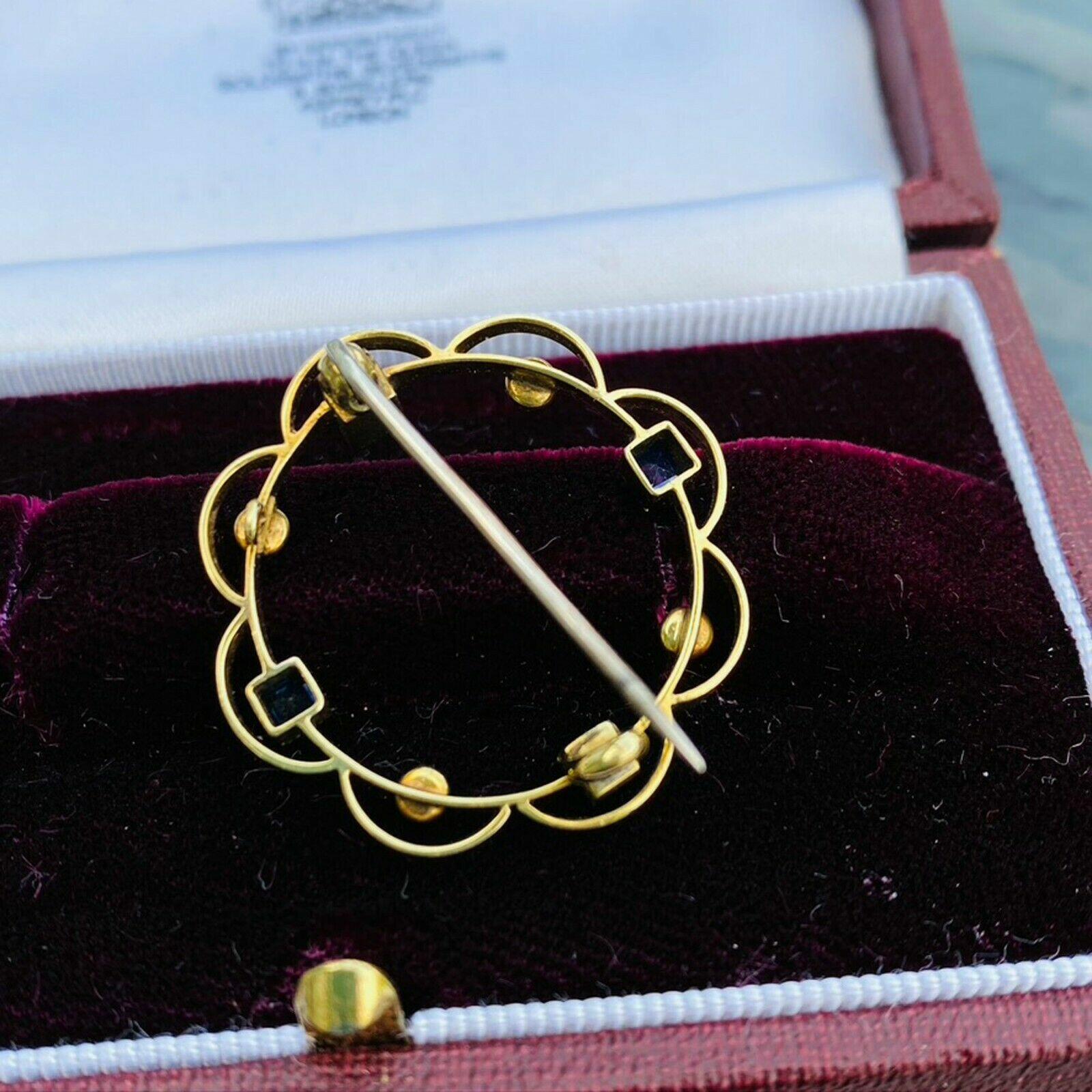 Antique gold circle brooch with seed pearls, sapphires, and scalloped frame. Edwardian era, 15ct gold hallmark, 28mm size, 3.8 grams.