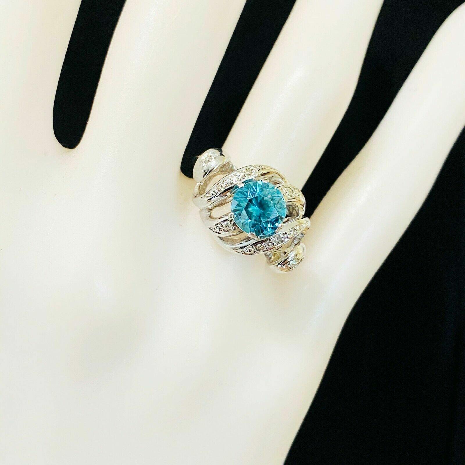 Stunning blue zircon cocktail ring with white gold setting and diamond accents, a true statement piece!