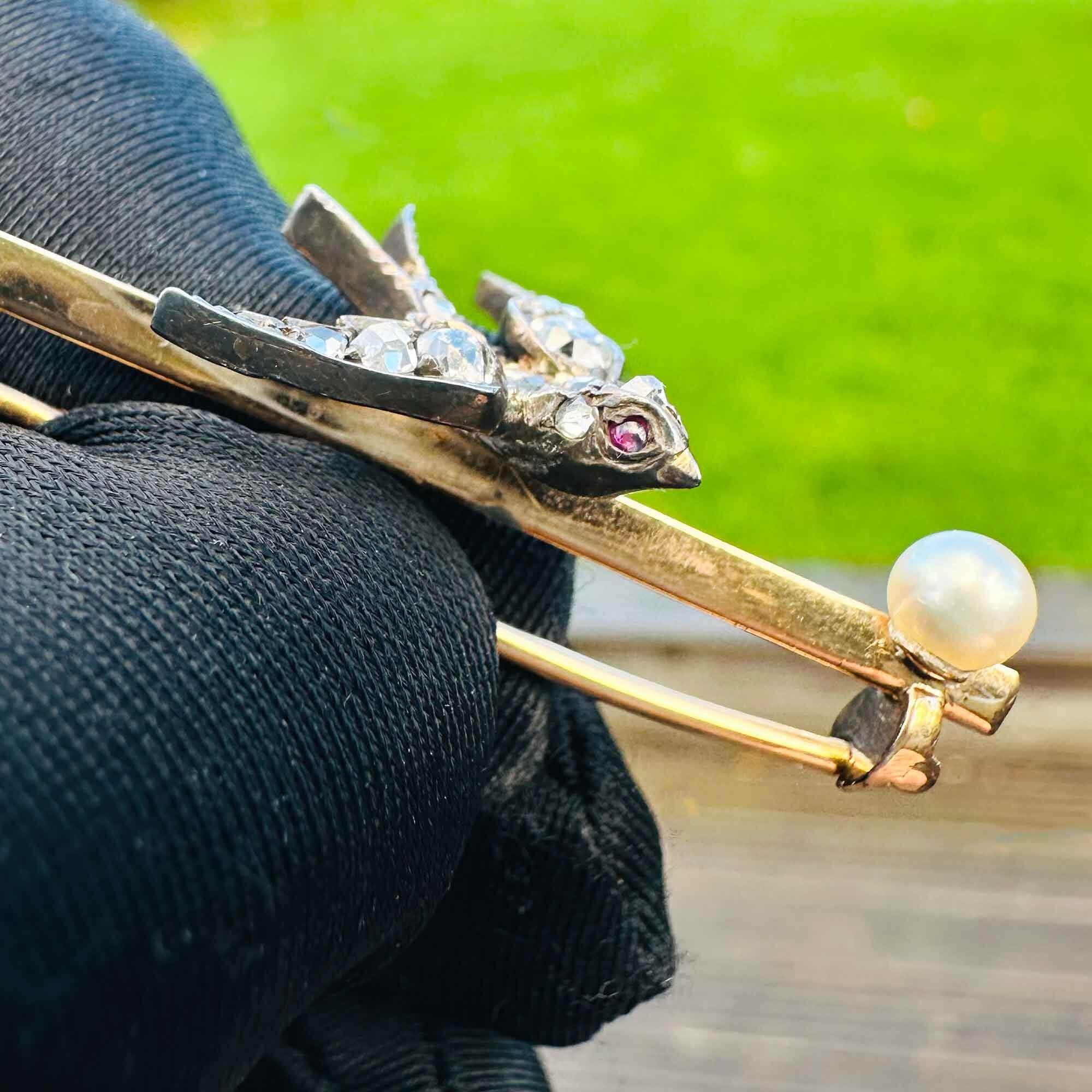 Edwardian swallow brooch with diamonds, rubies, and pearl on gold bar. Symbolizes eternal love, passion, and purity.