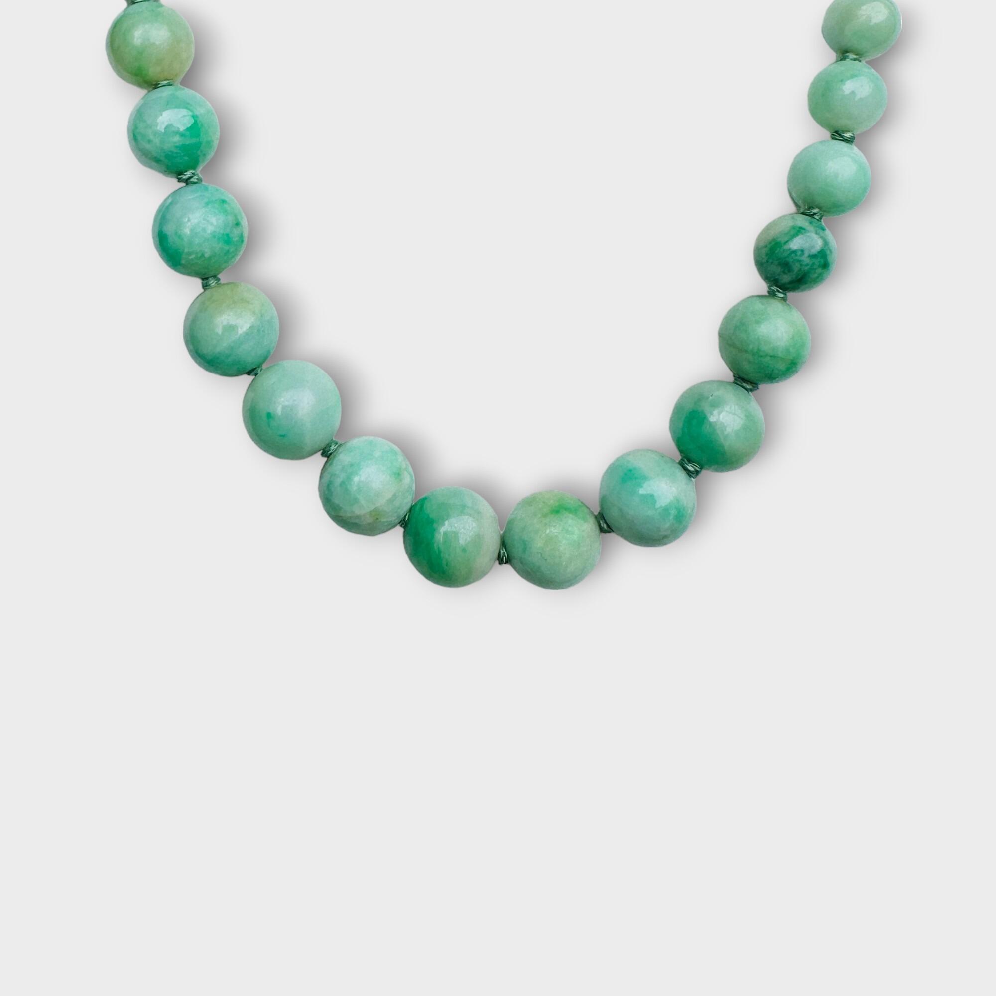 Hand-knotted Jadeite bead necklace with gold foliate clasp, featuring apple green marbled beads, Art Deco, 18 inches, 38 grams.