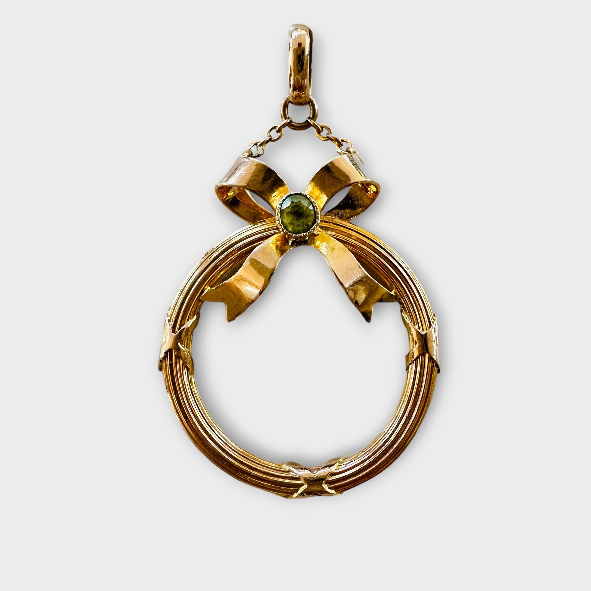 circular gold frame pendant with peridot studded bow