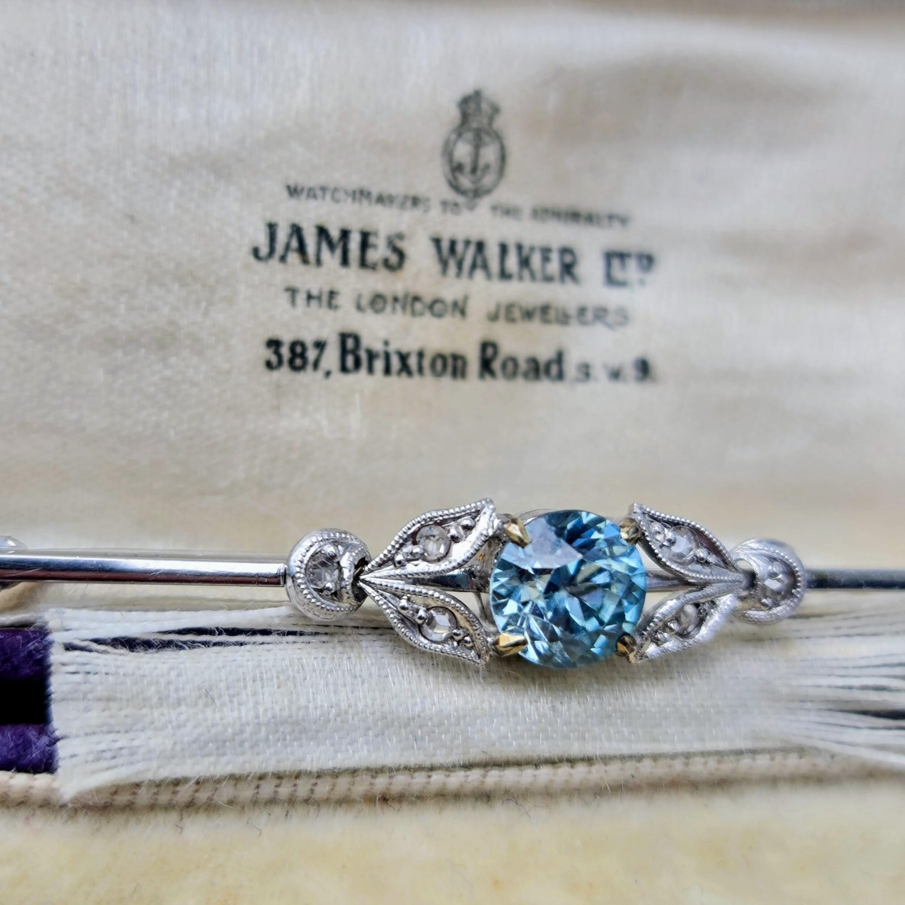 Exquisite Art Deco bar brooch with 1.00ct blue zircon, rose-cut diamonds, platinum detailing, and 9ct white gold bar and pin.
