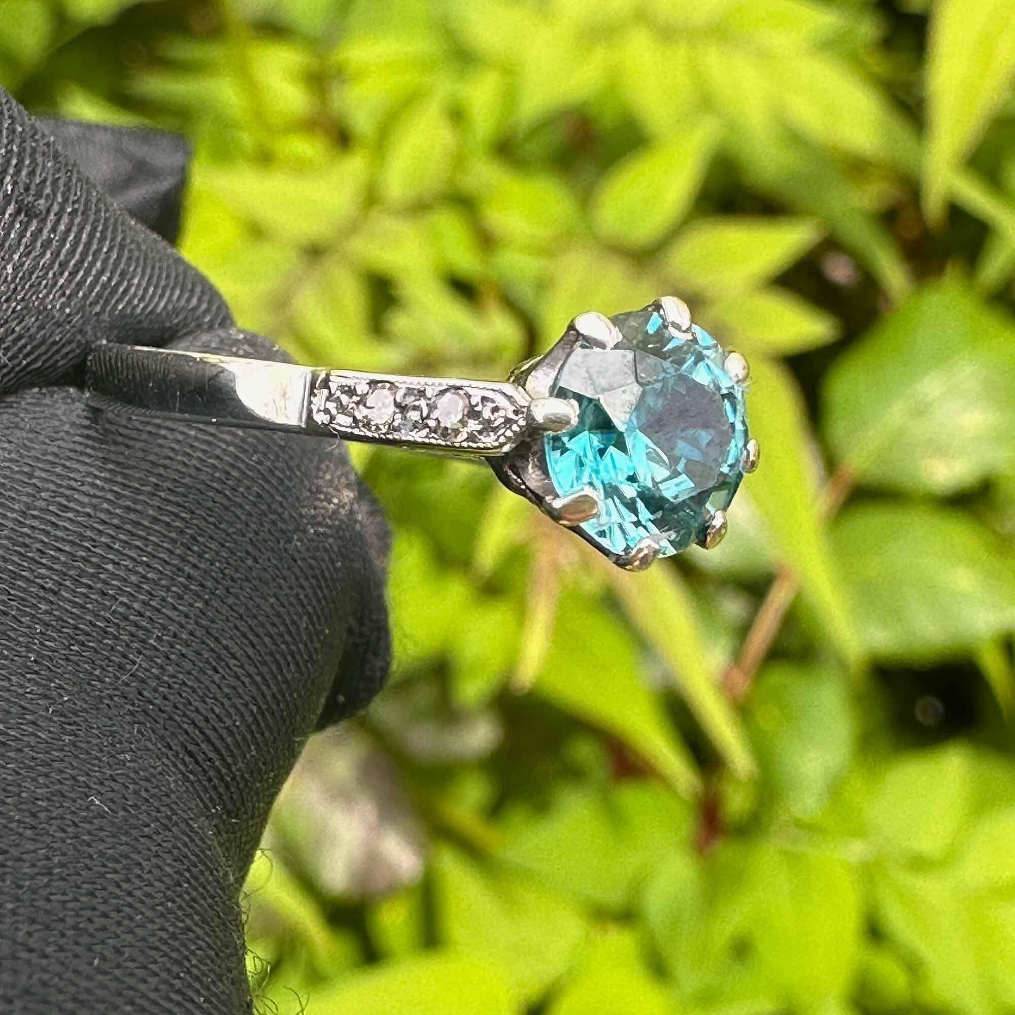 white gold solitaire ring with blue zircon and diamond accents on shoulders