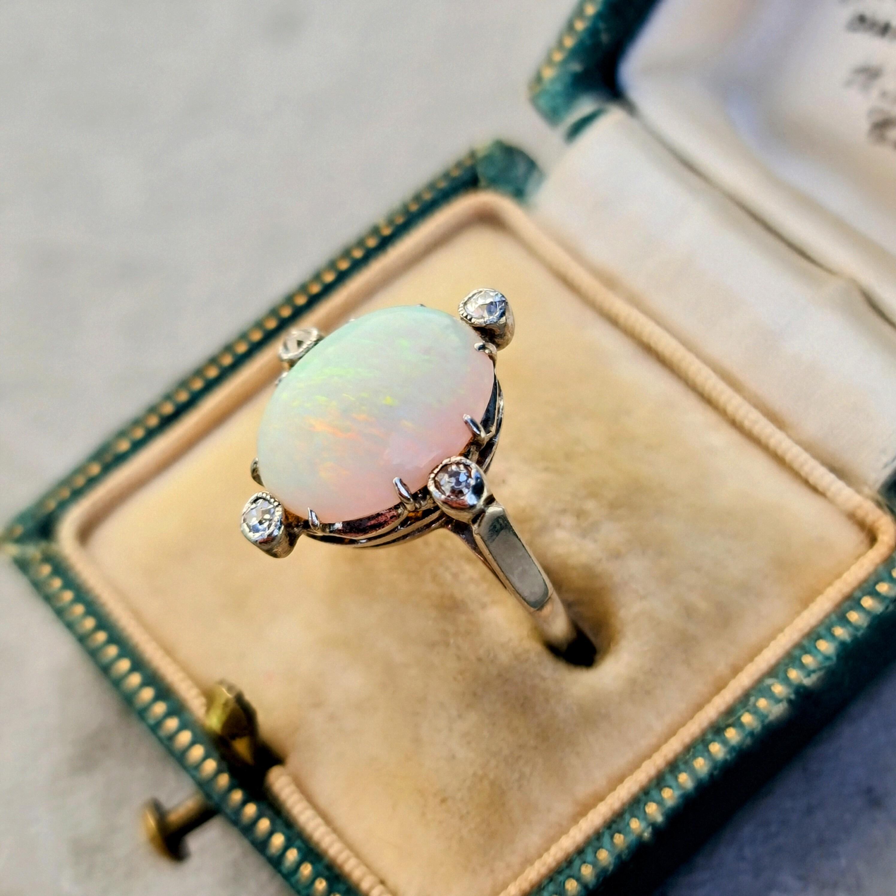 Cocktail ring with large oval shaped opal and NSEW diamond accents set into 18ct white gold