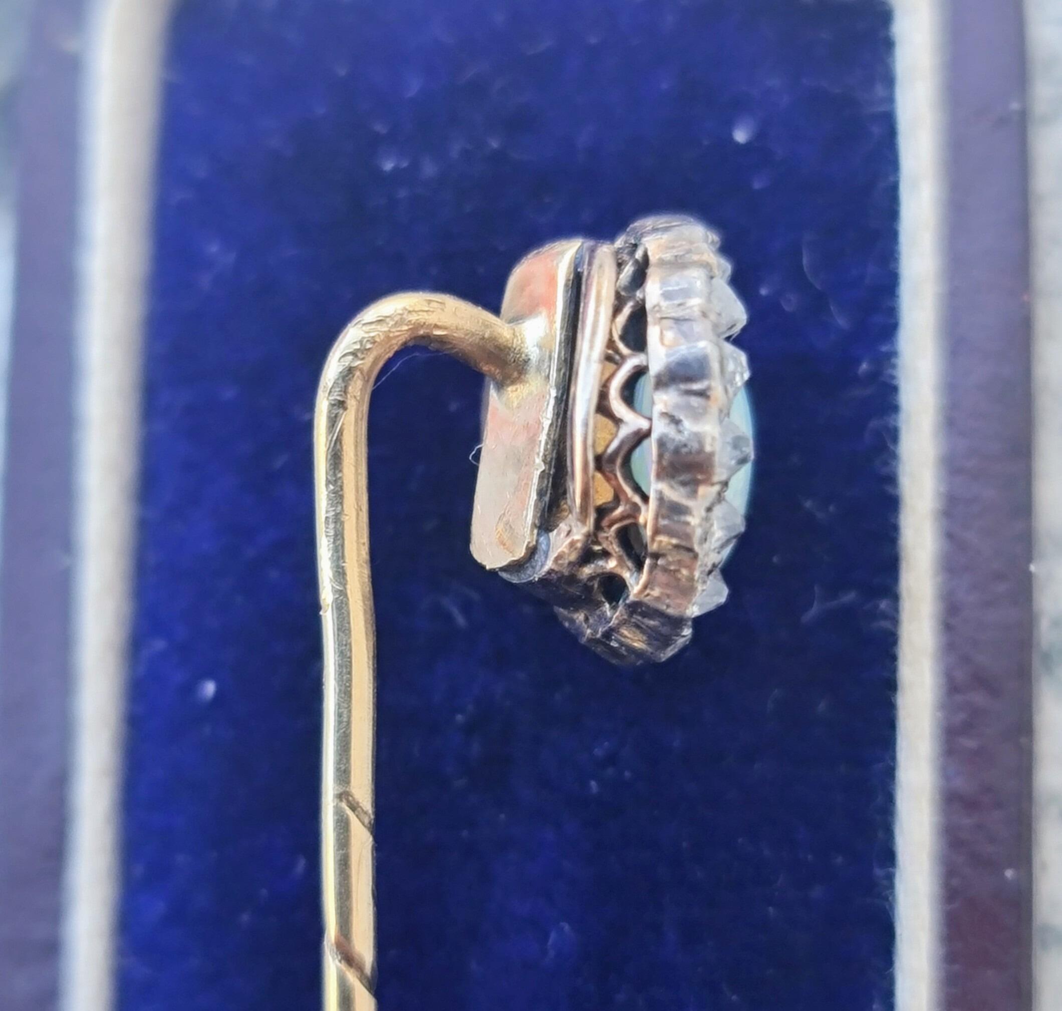 antique stick pin with round opal framed with old cut diamonds set in 15ct yellow gold