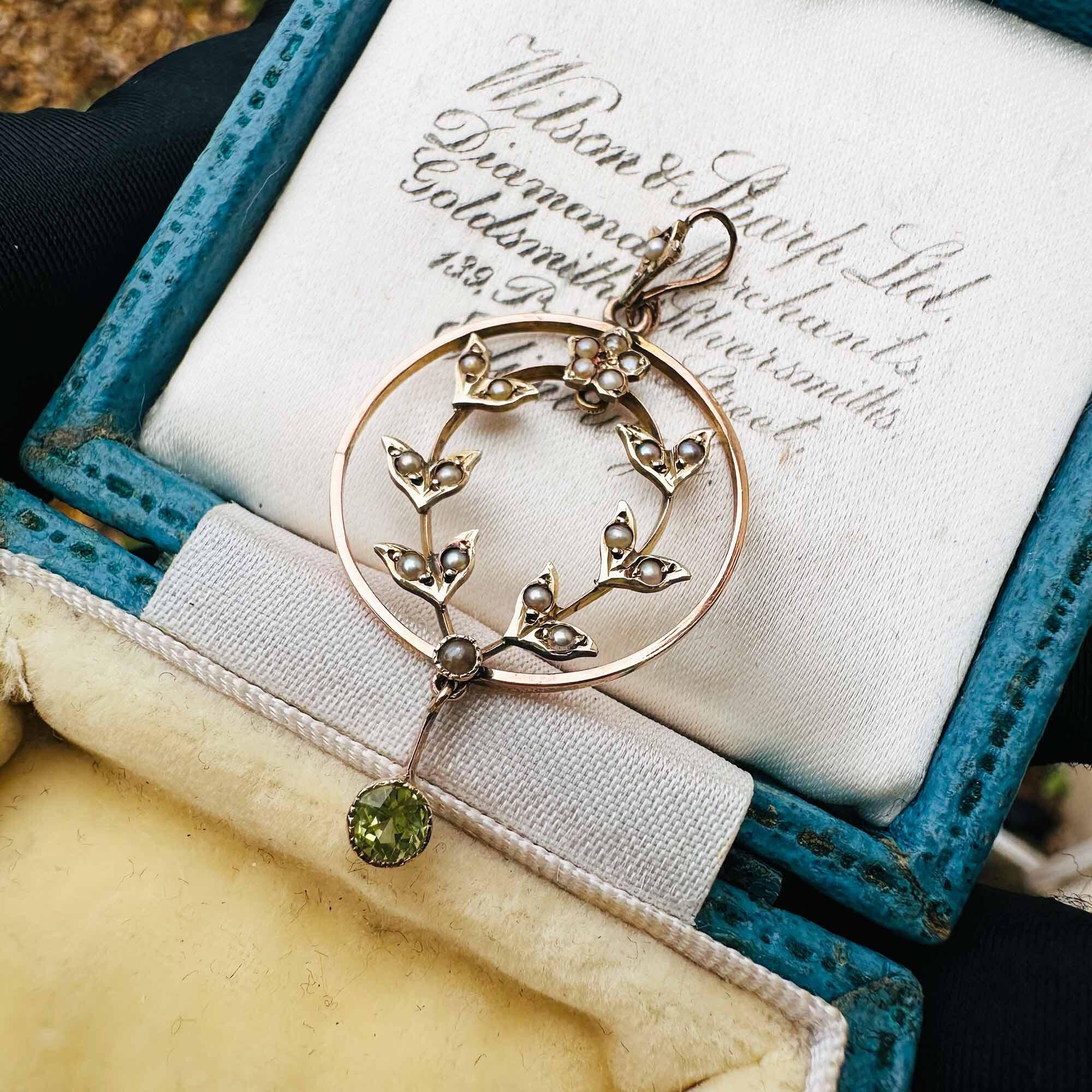 Art Nouveau pendant with floral design, seed pearls, peridot drop, 9ct yellow gold.