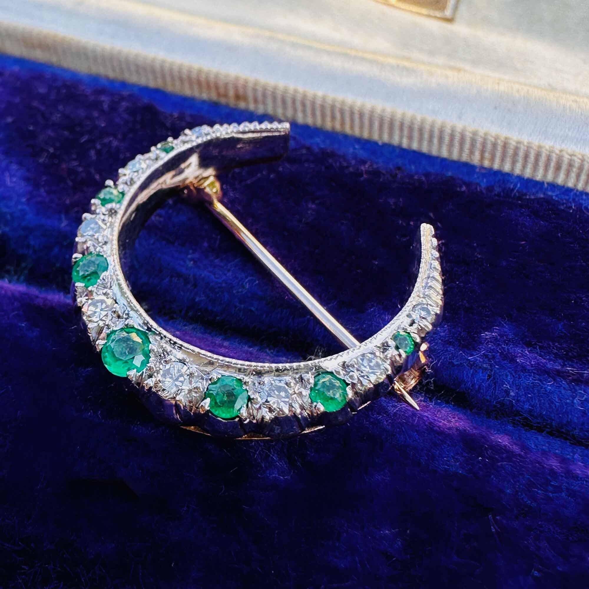 crescent moon brooch in 9ct white gold adorned with alternating emeralds and diamonds