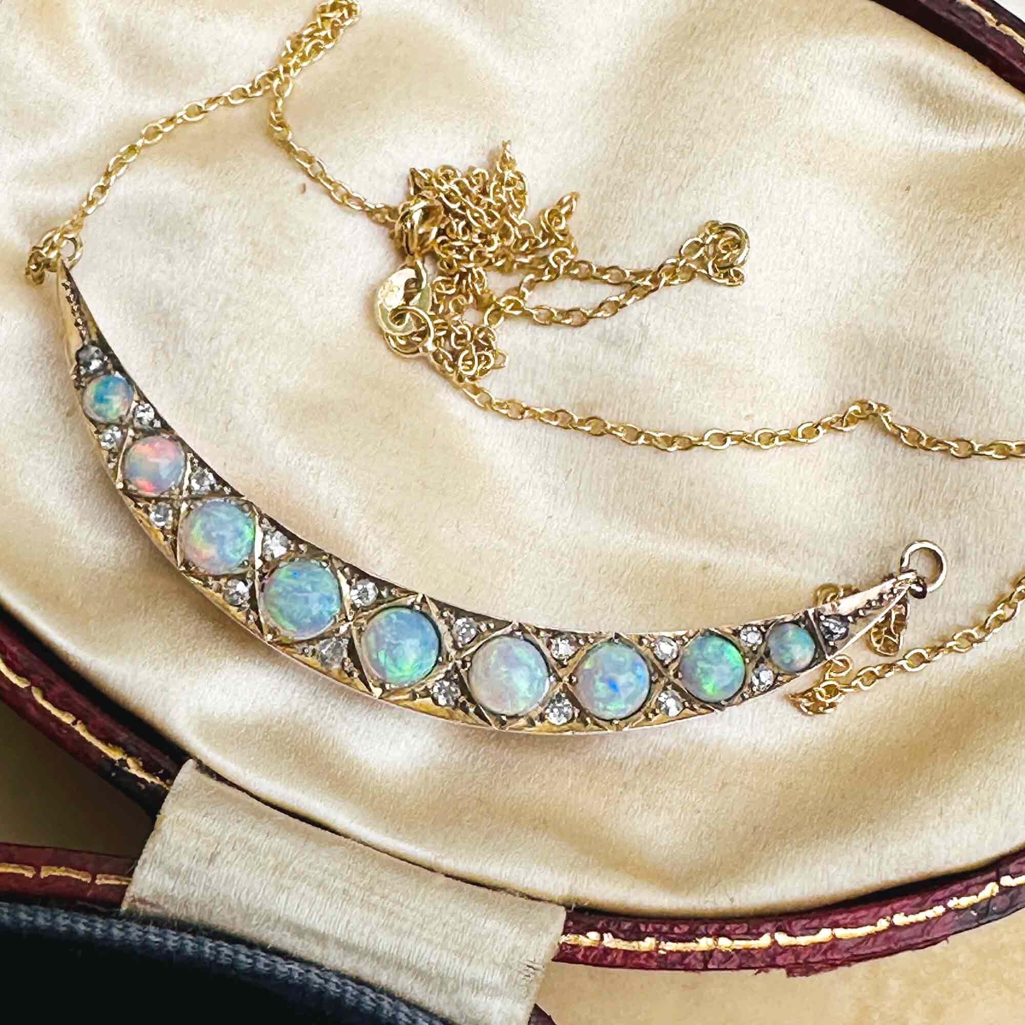 a necklace with 15ct gold, opal and diamond studded crescent moon attached to a 9ct gold chain.