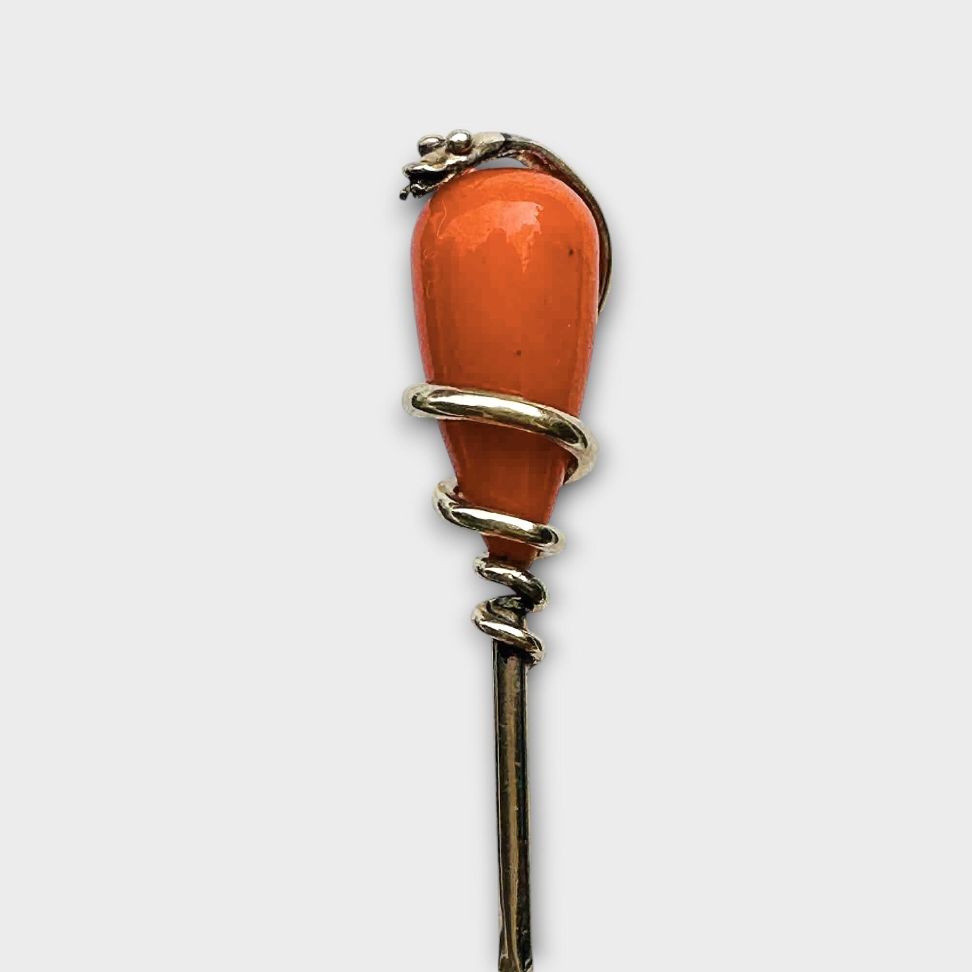 Victorian stick pin featuring a 15ct gold snake coiled around an oval natural coral piece on a barley twist pin