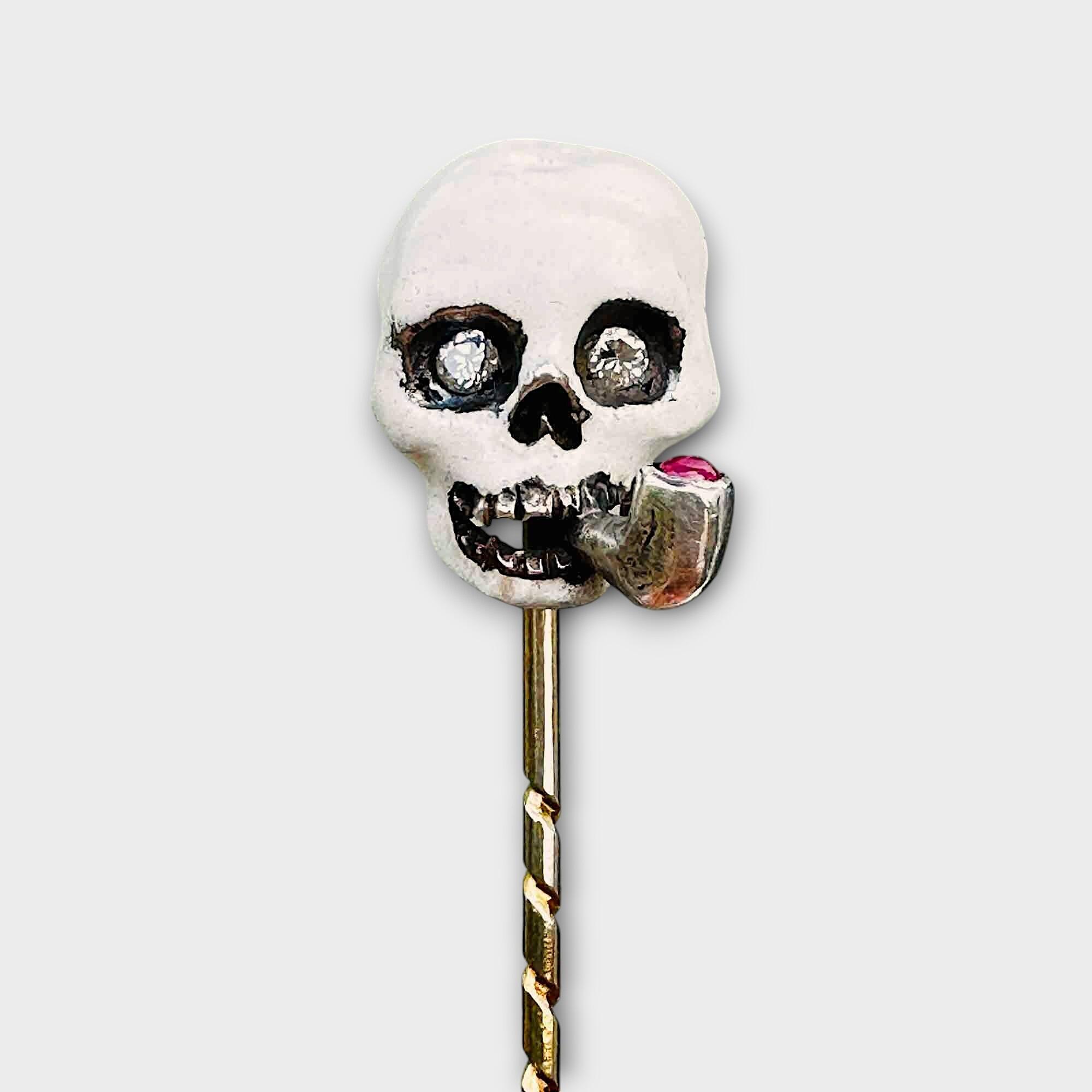 vintage memento mori smoking skull stick pin with white enamel, diamond eyes, and ruby pipe all set in silver on a barley twist pin