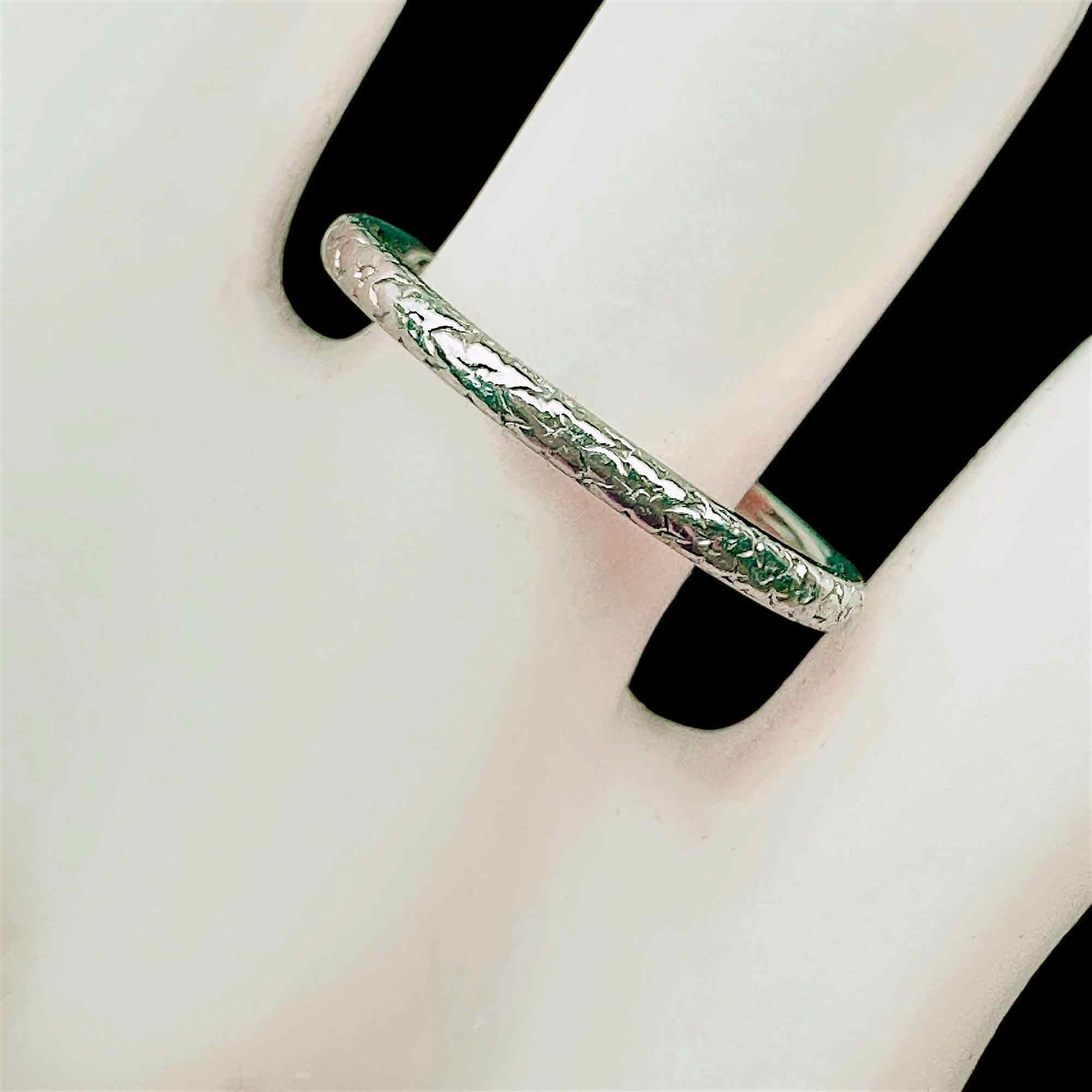 Antique platinum hand engraved orange blossom wedding band on hand model.