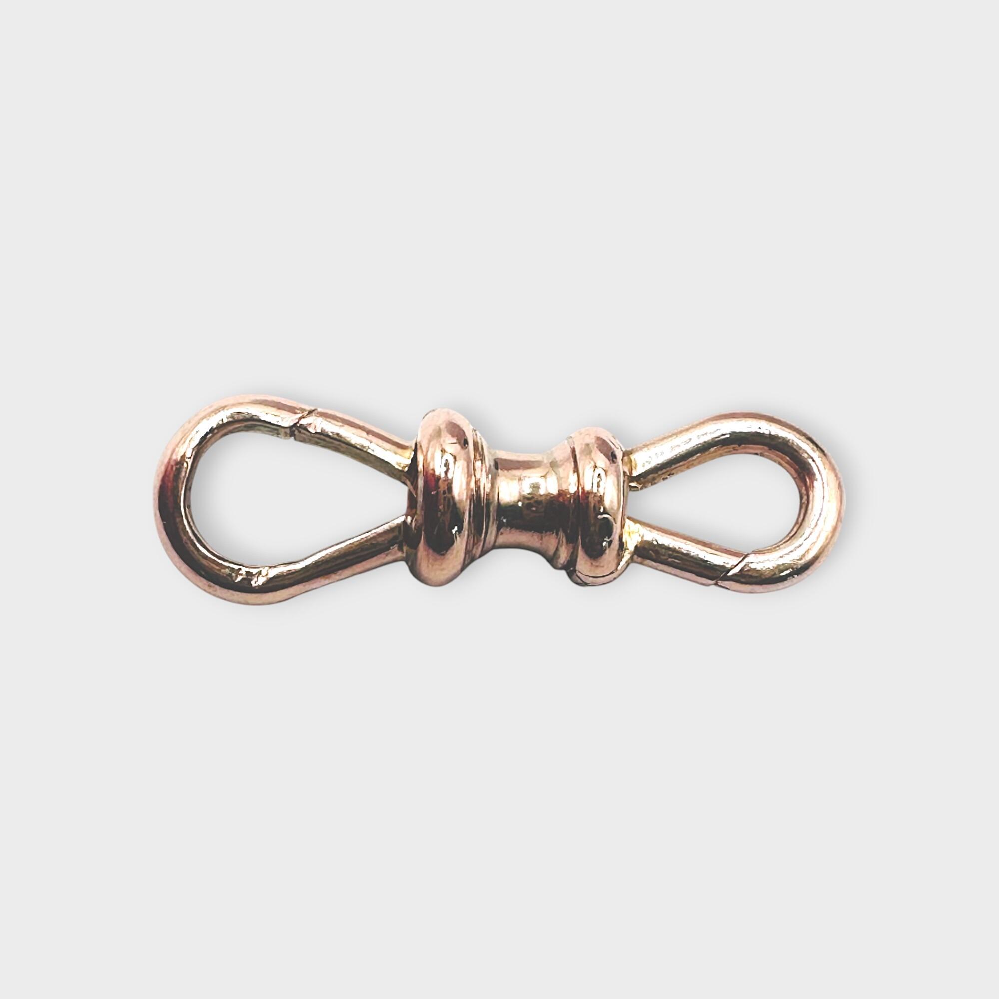 Antique 9ct rose gold double dog clip clasp on grey background.
