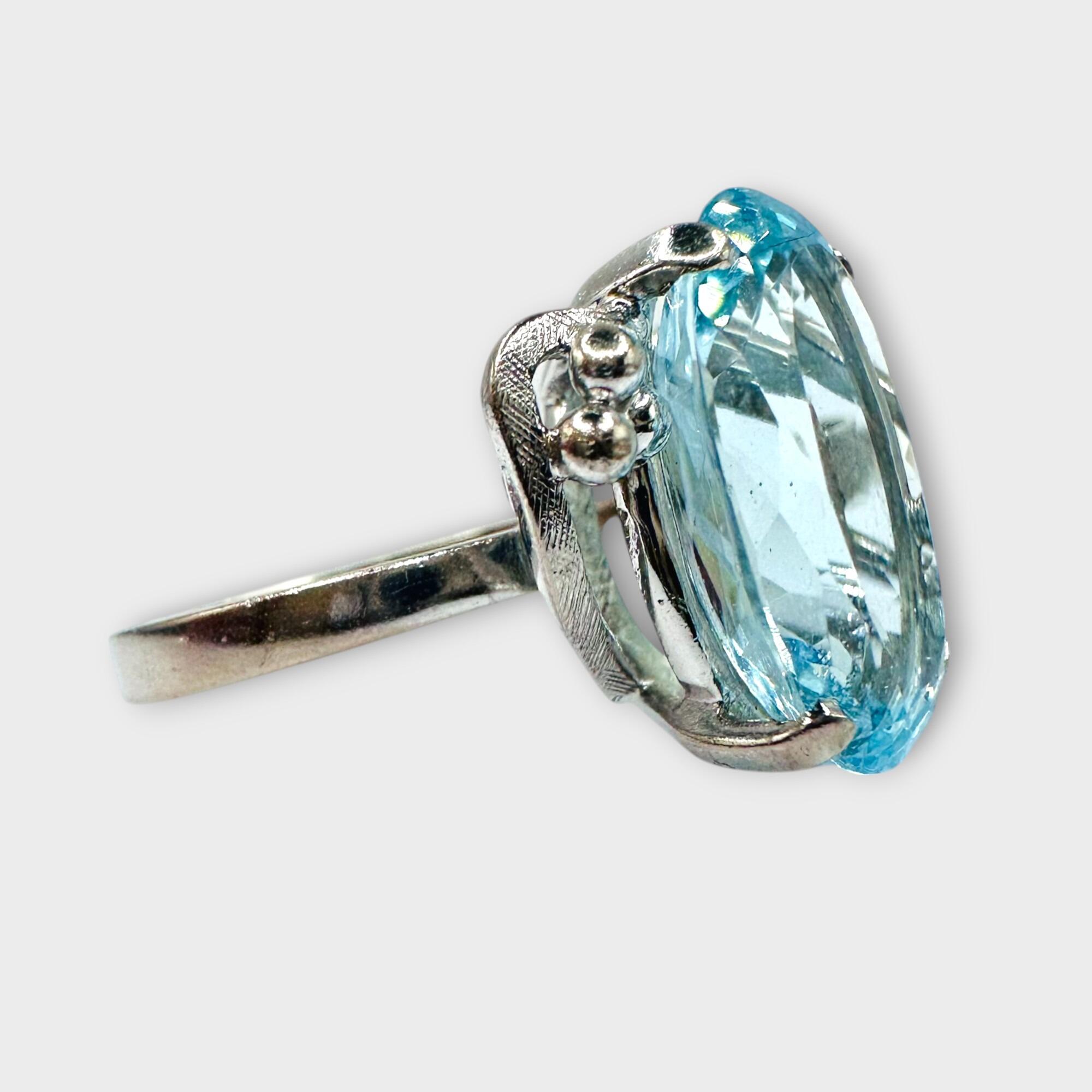 18ct white gold aquamarine cocktail ring on grey background, side view