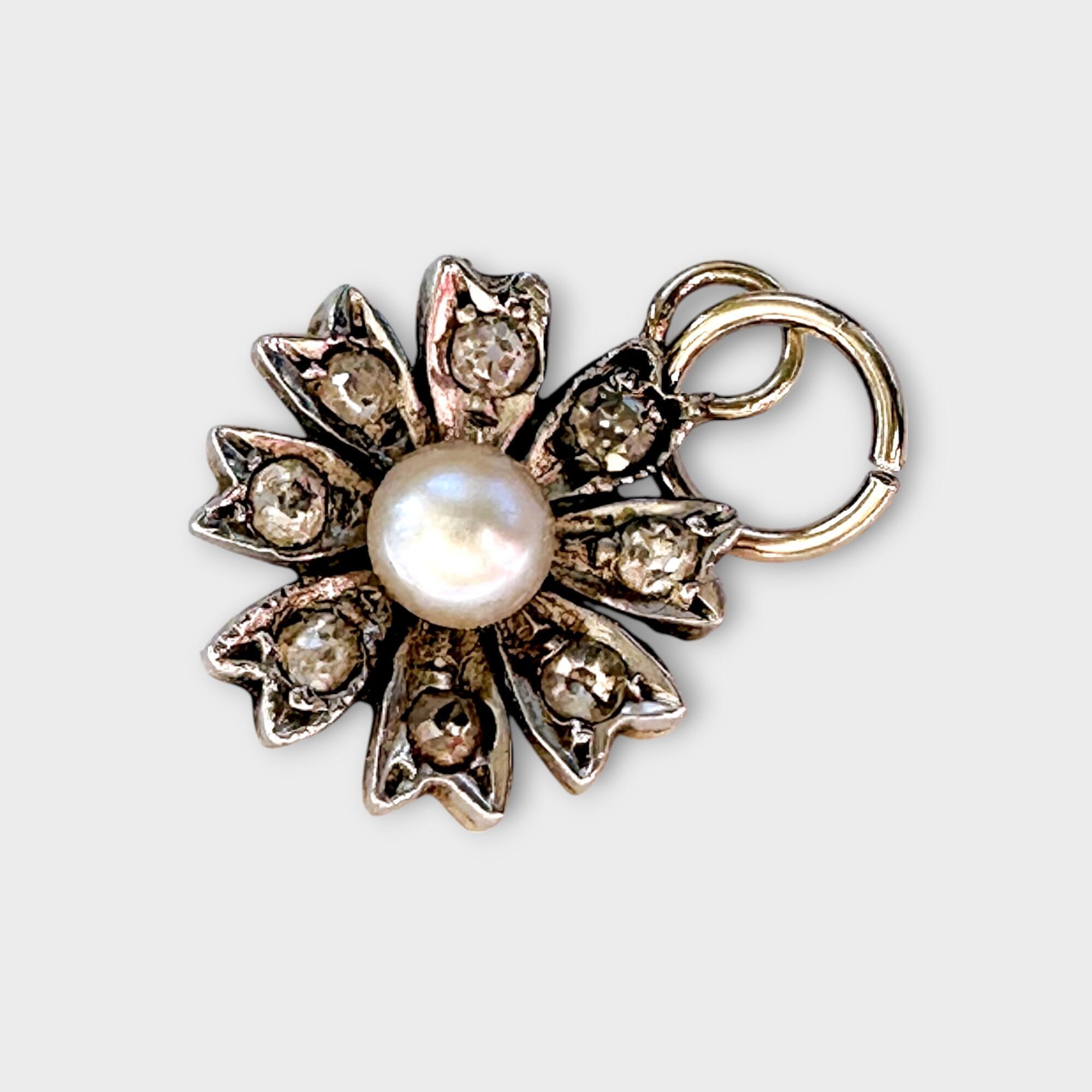 Victorian diamond and pearl daisy charm, pendant on grey background.