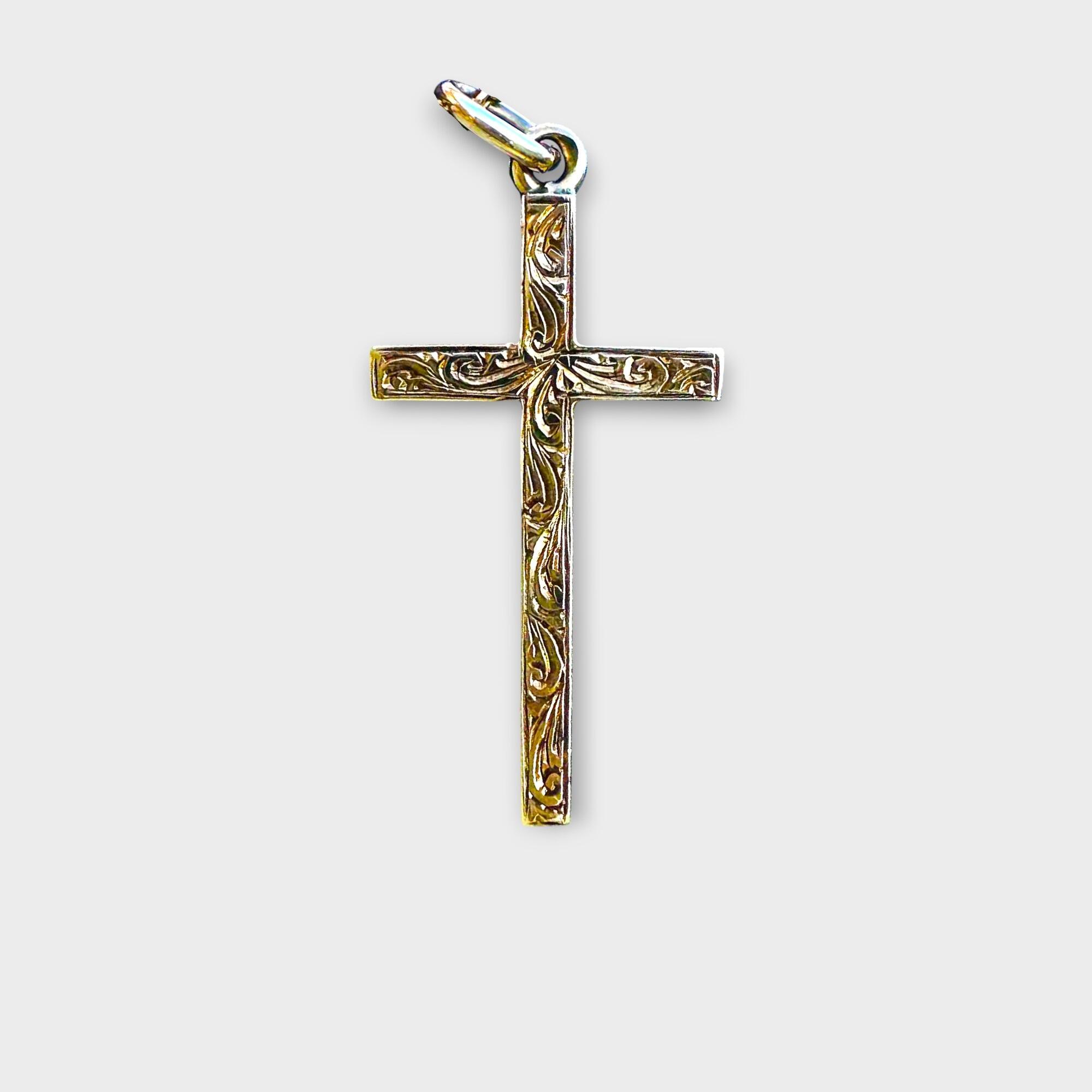 Edwardian 9ct gold foliate cross on grey background.
