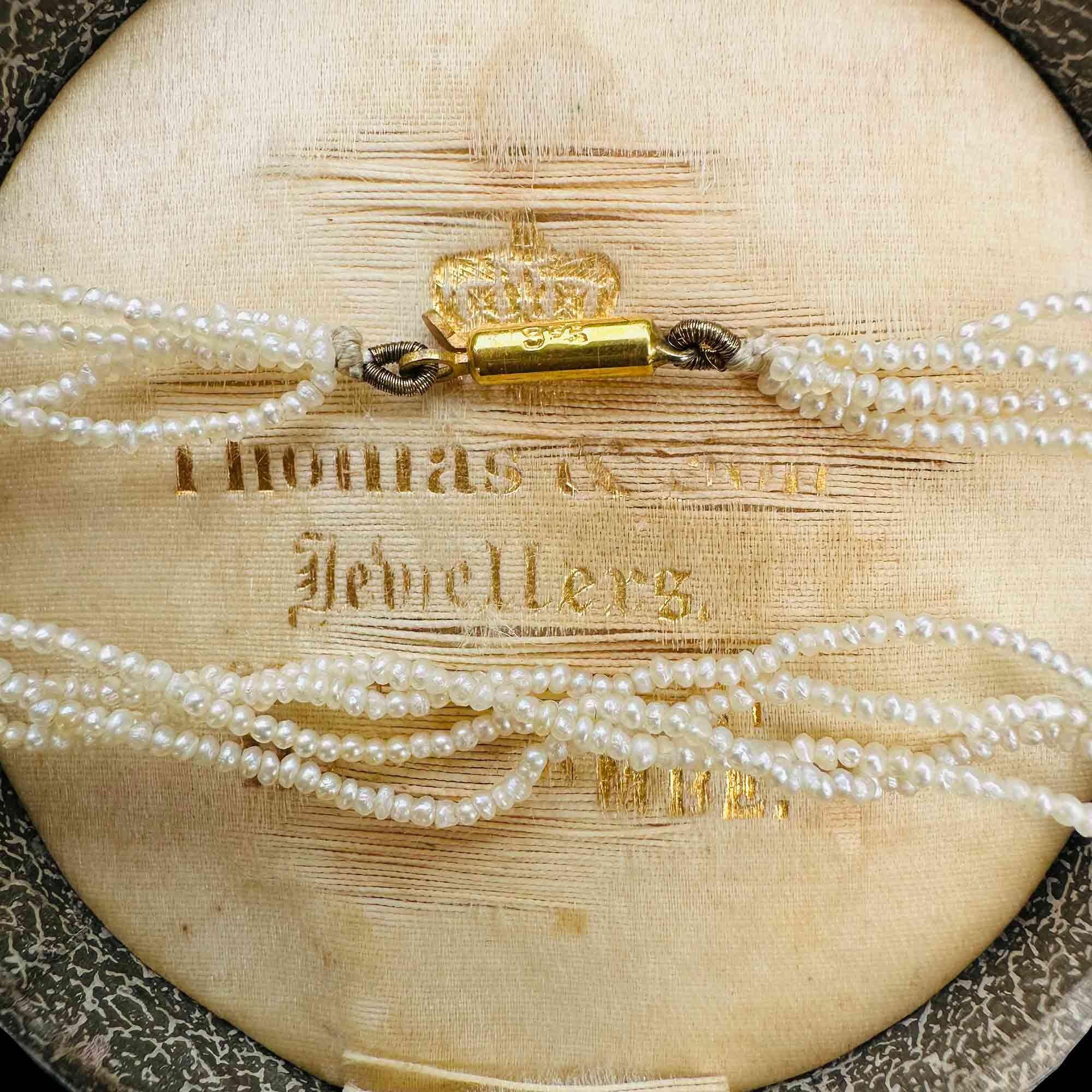 Georgian seed pearl four row necklace on 9k gold barrel clasp on antique box.