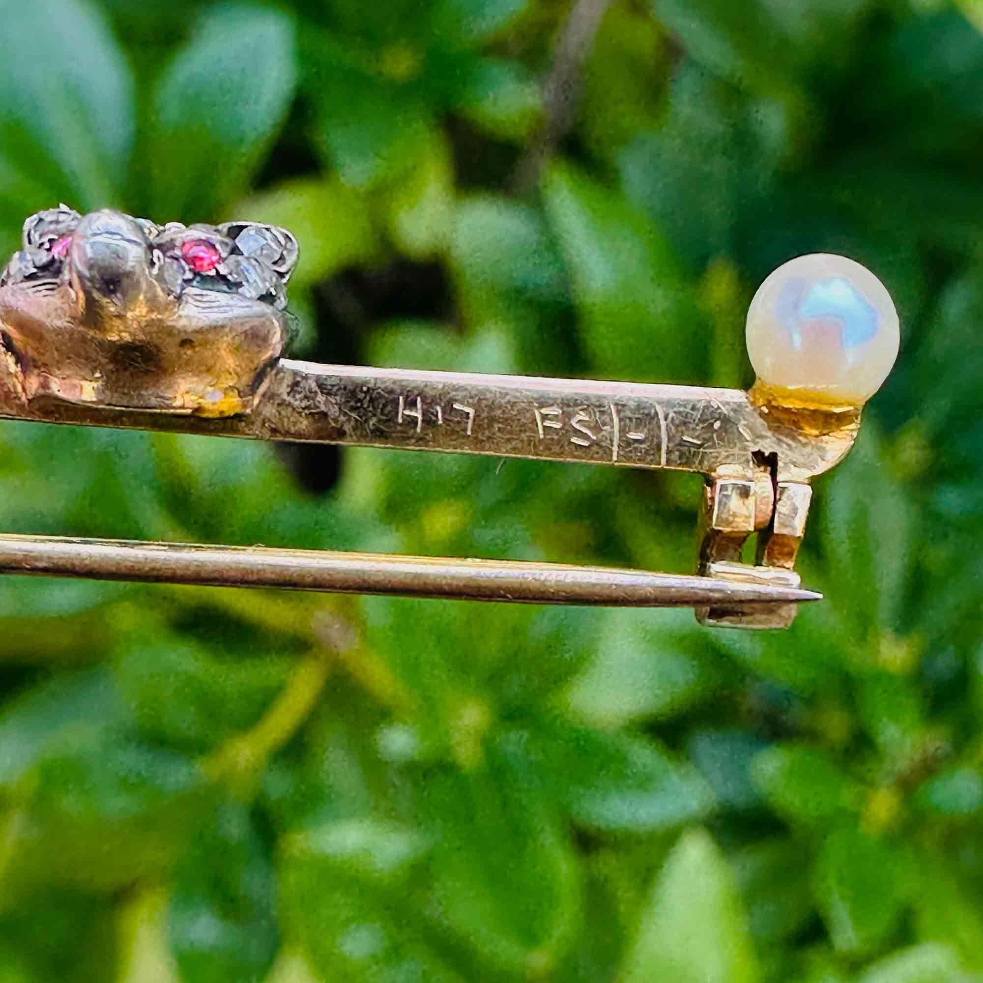Victorian 15ct Gold Diamond & Ruby eyed fox brooch with pearl finials with hallmark, in a garden background.
