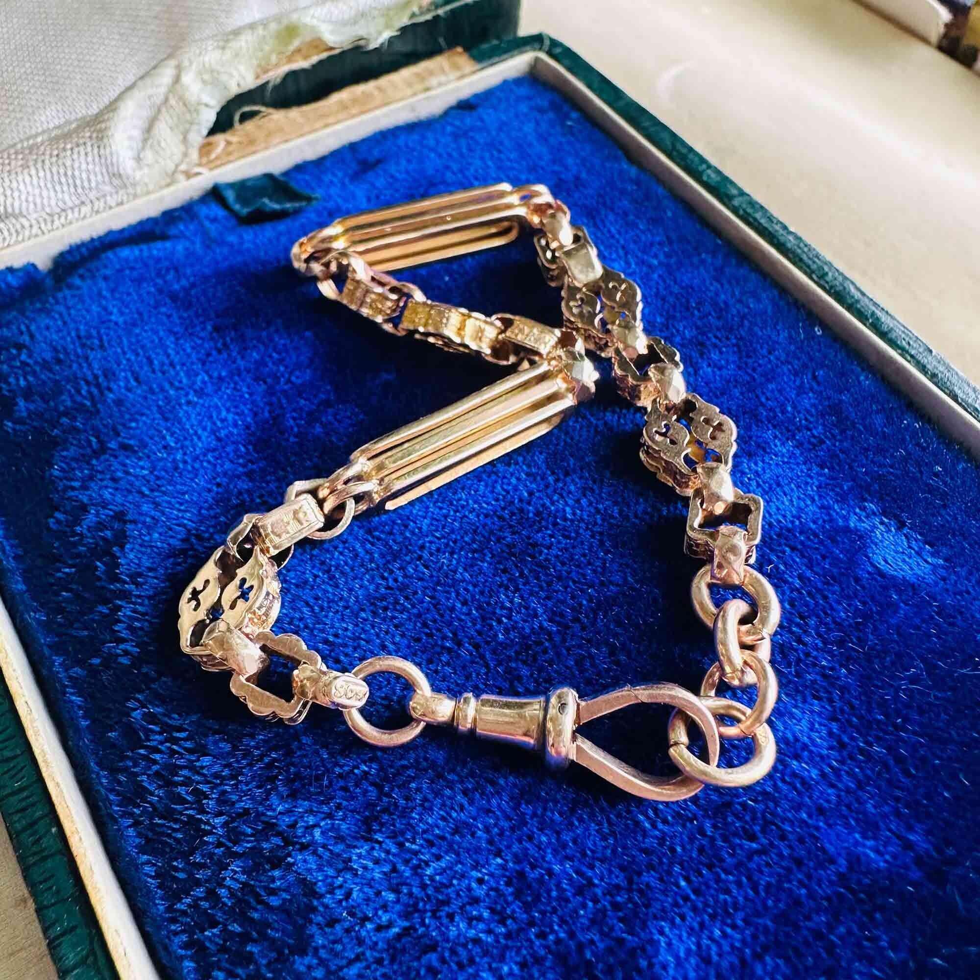 Antique 9ct rose gold bracelet with decorative star links and faceted chain, measuring 7.75 inches in length, coiled up on blue velvet pad.