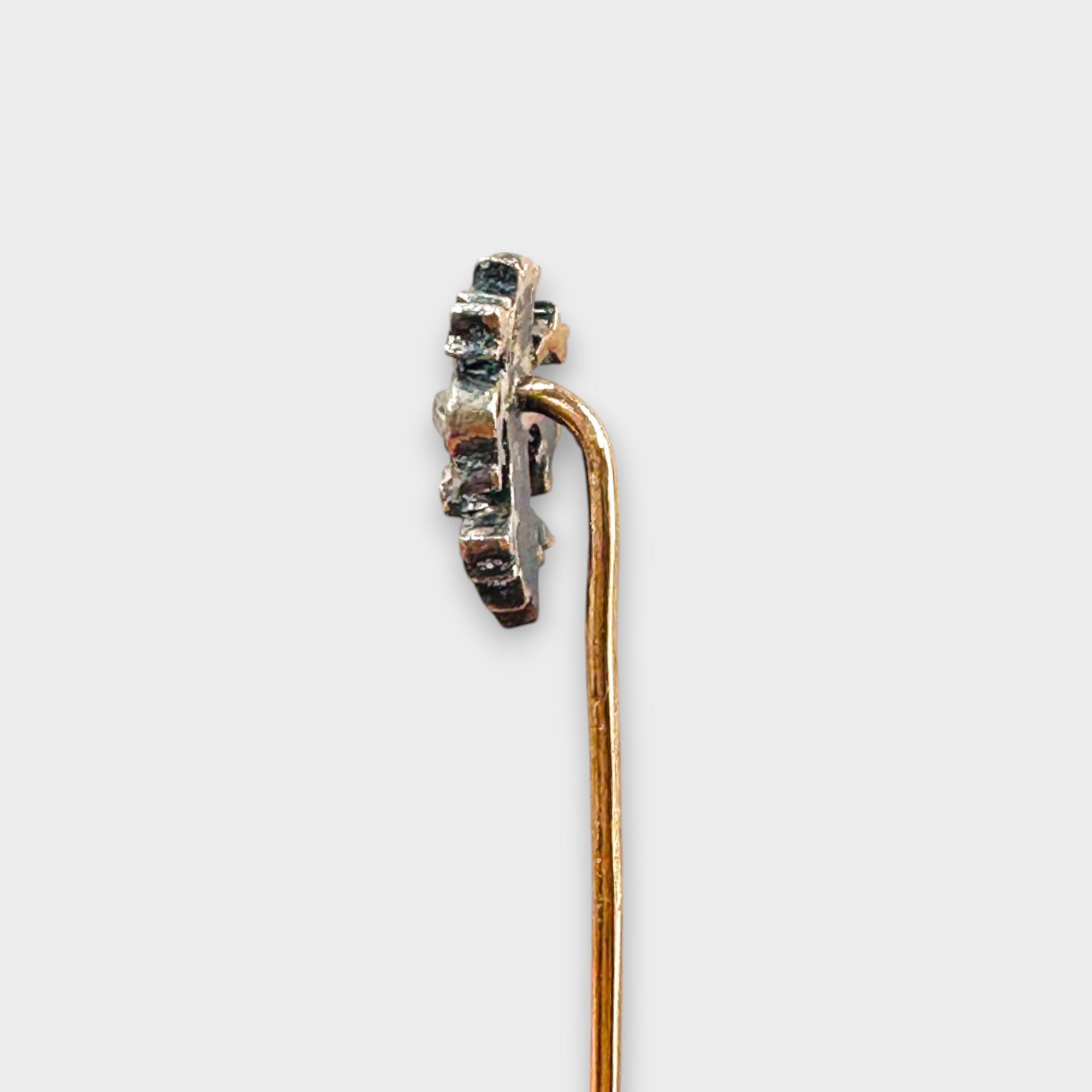 Antique stick pin crafted in 15k rose gold featuring a delicate diamond-set fleur-de-lys design on grey background, side profile.
