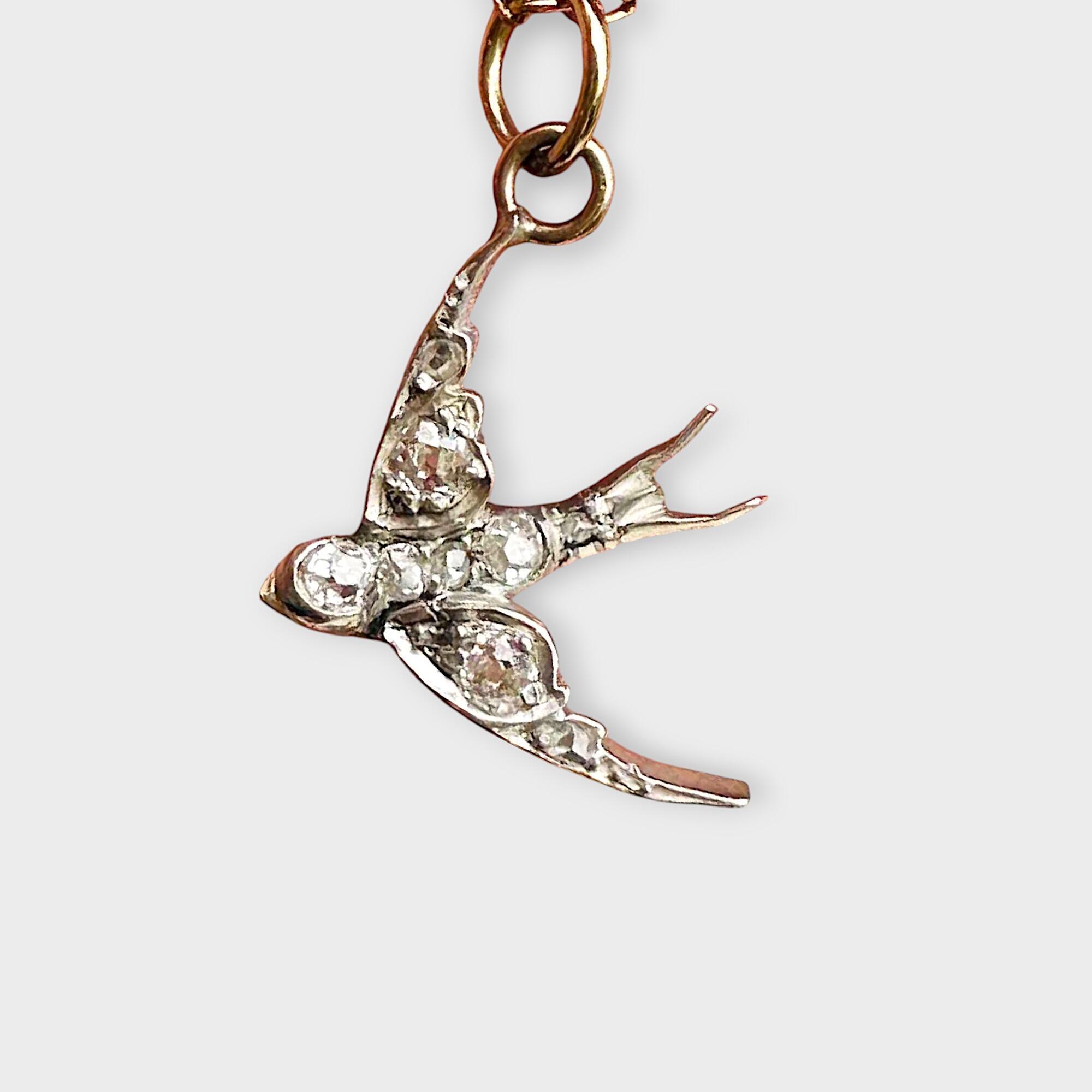 Antique Diamond swallow pendant on grey background.