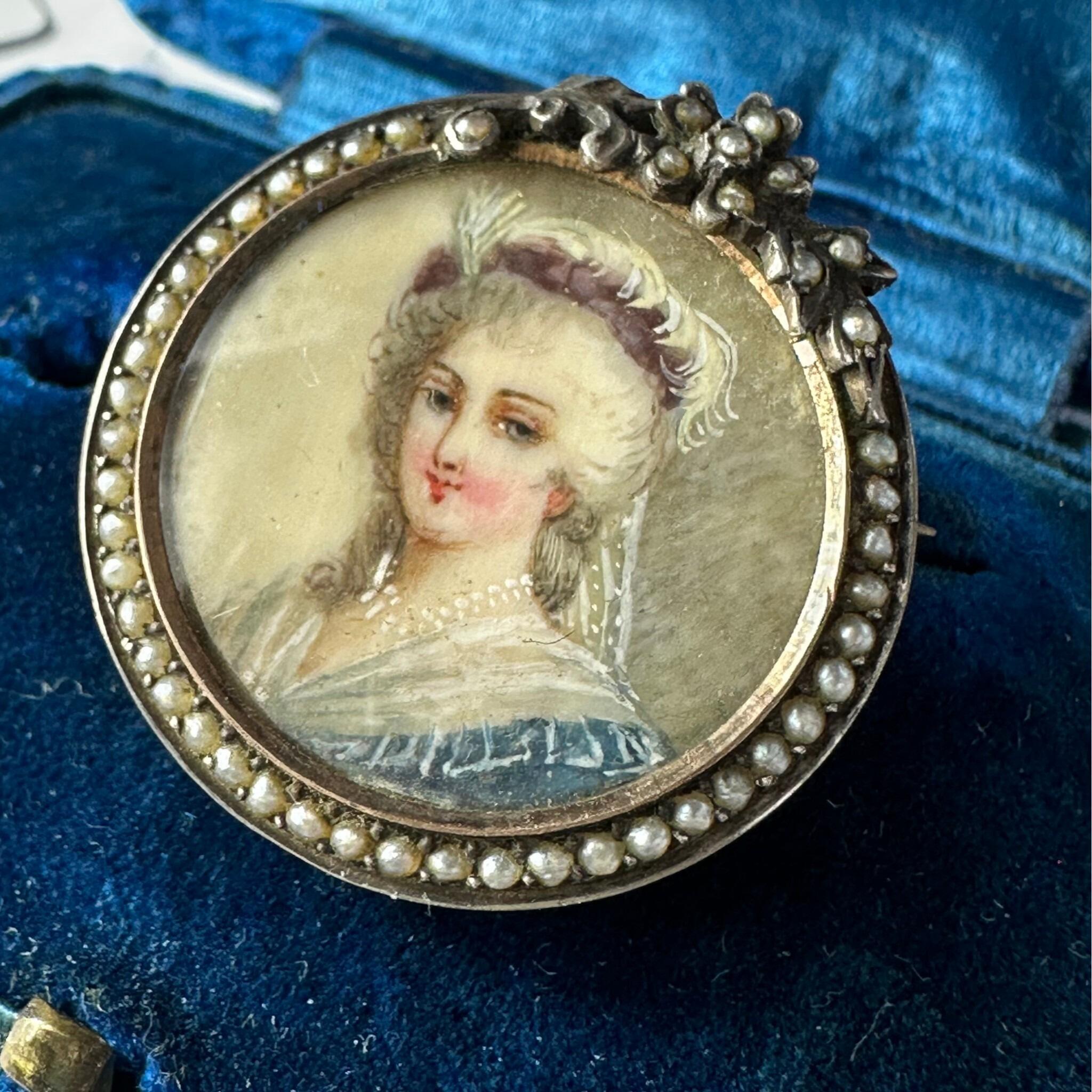 Georgian Marie Antoinette & Silver Seed Pearl Portrait Brooch displayed on blue antique box