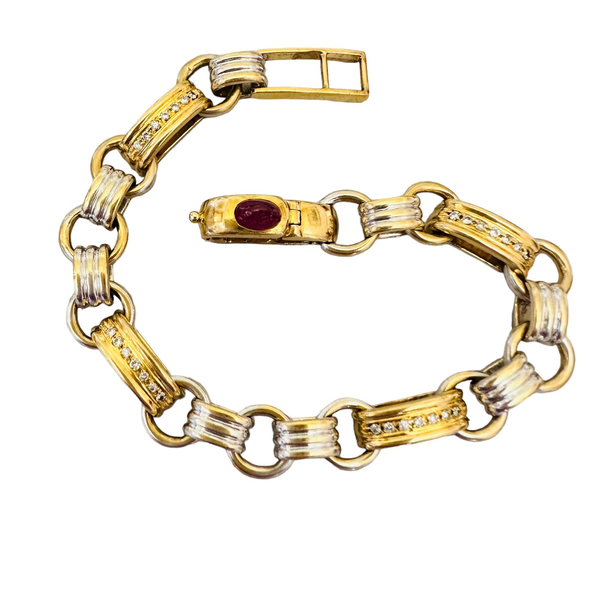 yellow and white gold multi link bracelet with diamonds and a ruby with white background