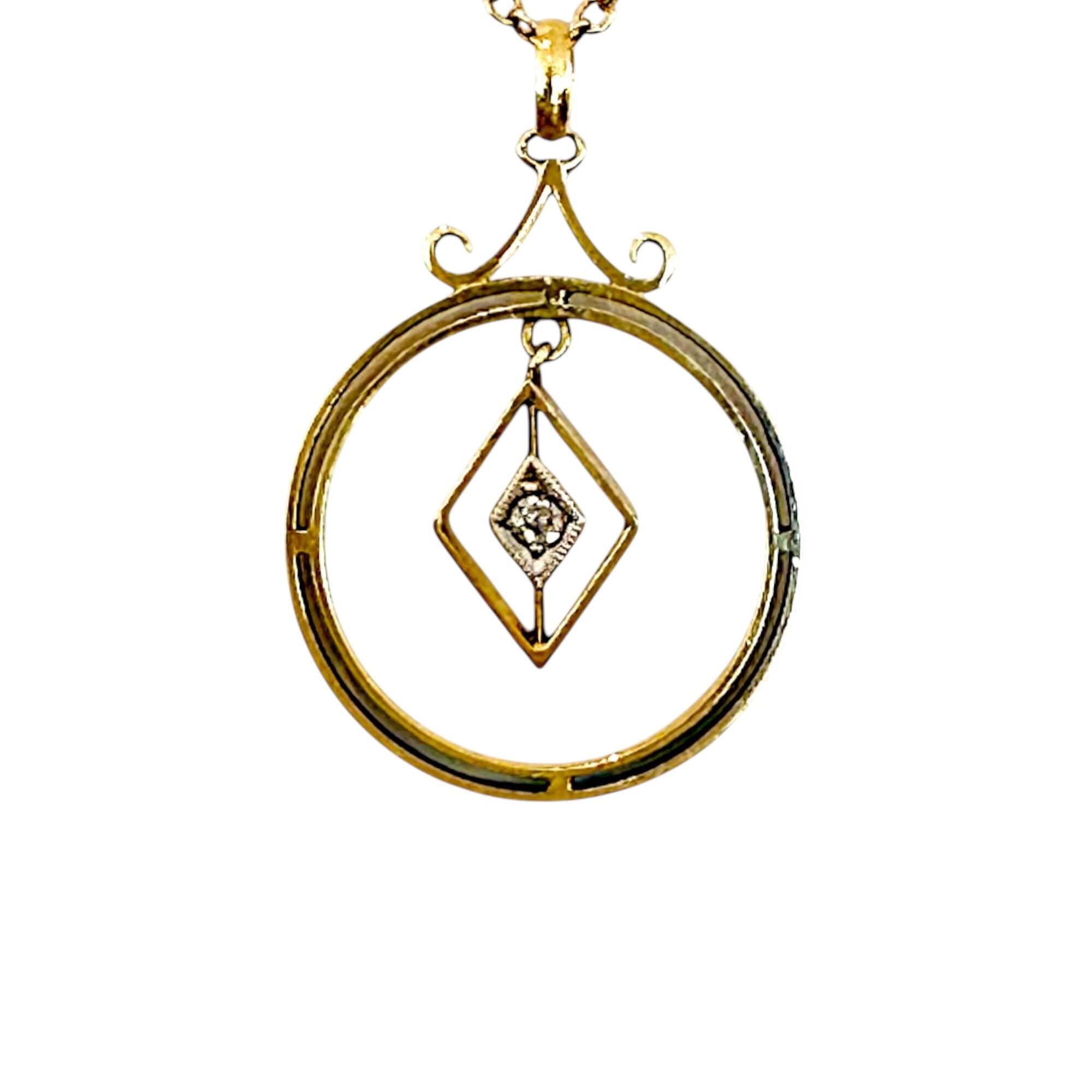 Front view of Art Deco 15k gold pendant with central diamond and geometric design, white background.