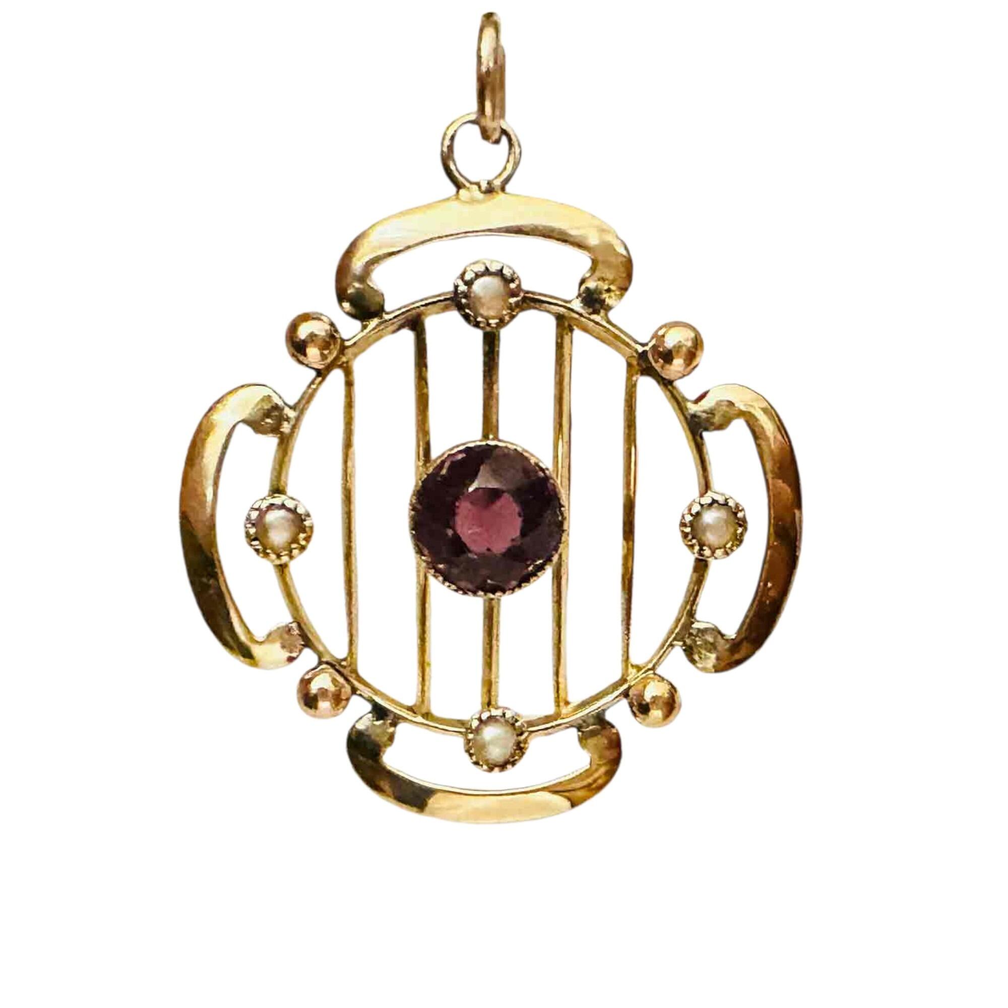 yellow gold art nouveau pendant with amethyst and pearl detail on white background