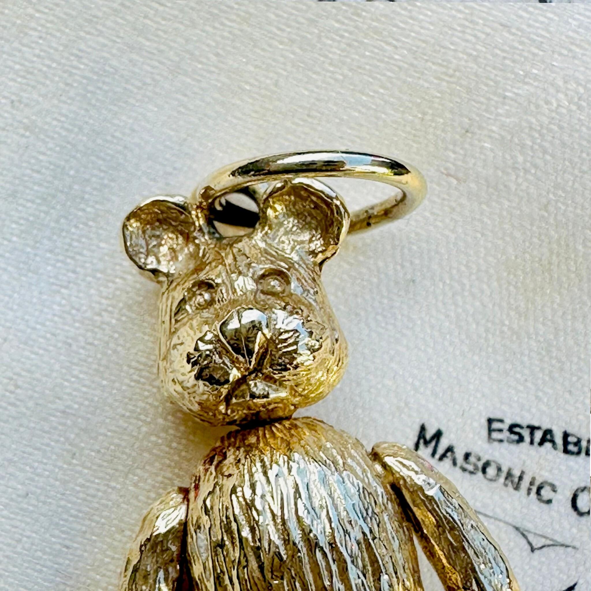close up of Vintage Gold Articulated Teddy Bear Charm Pendant laying on antique box